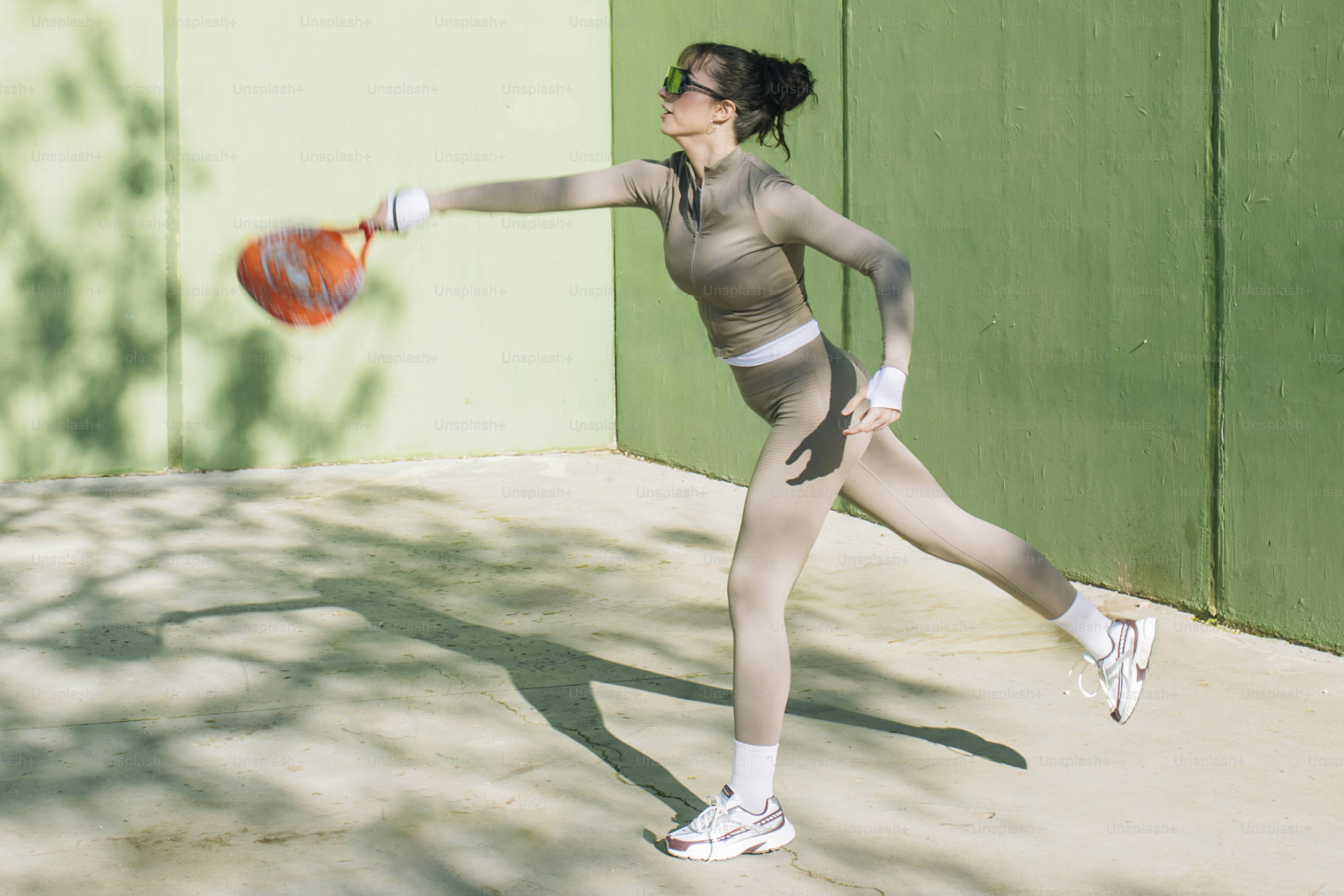 Frau, die Padeltennis auf einem grünen Platz spielt.