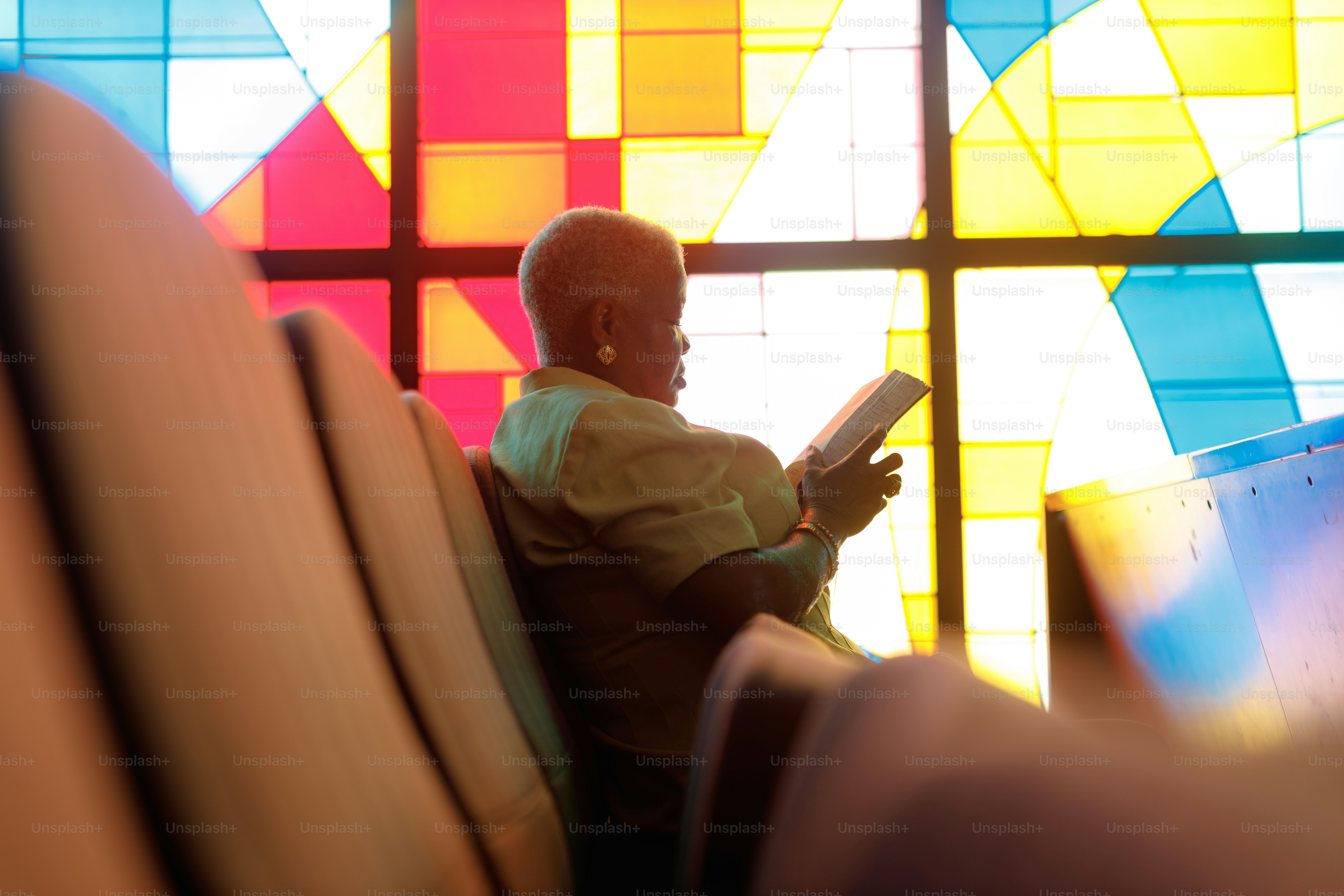 Woman reading a book in a church pew.