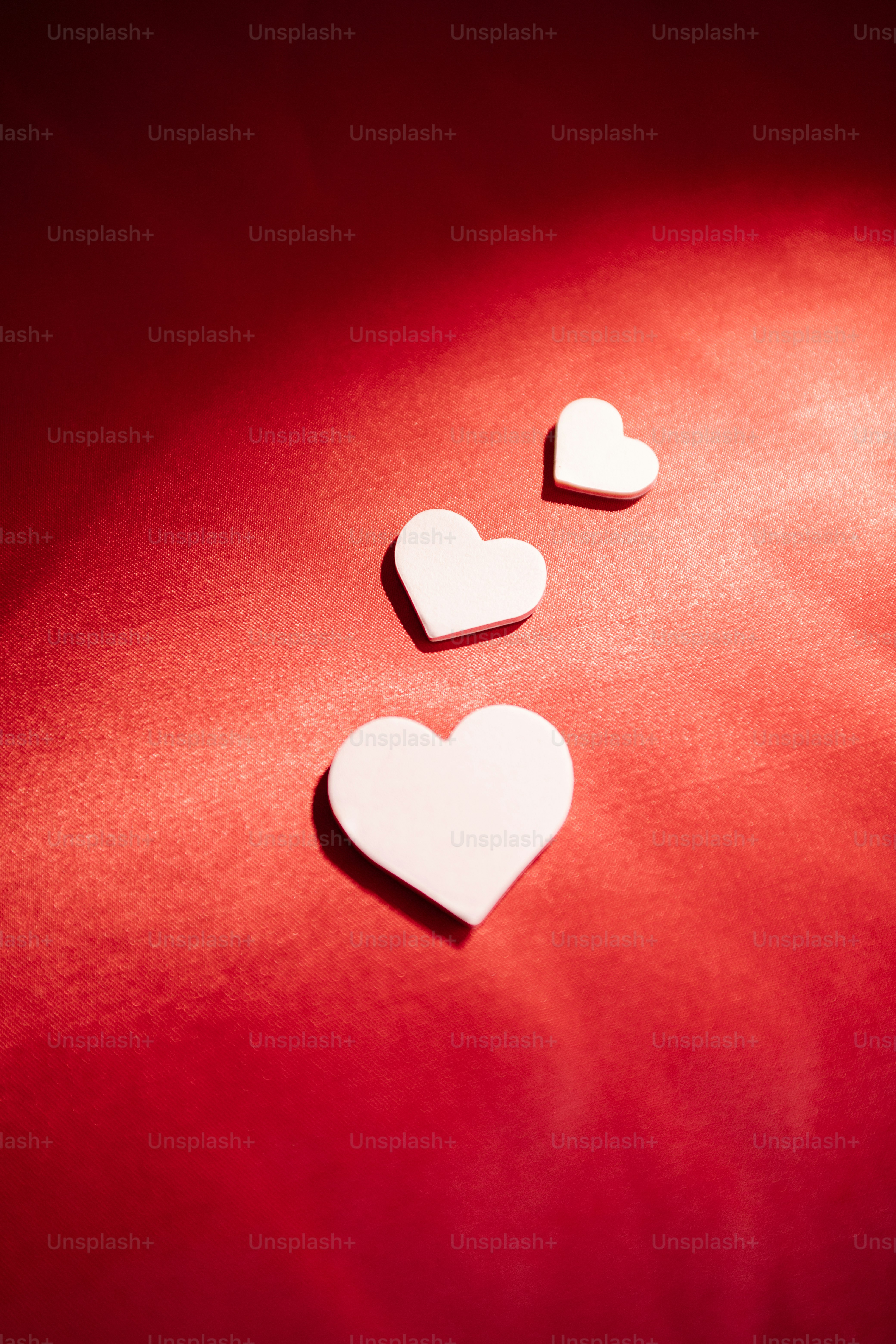 Three white hearts on a red background