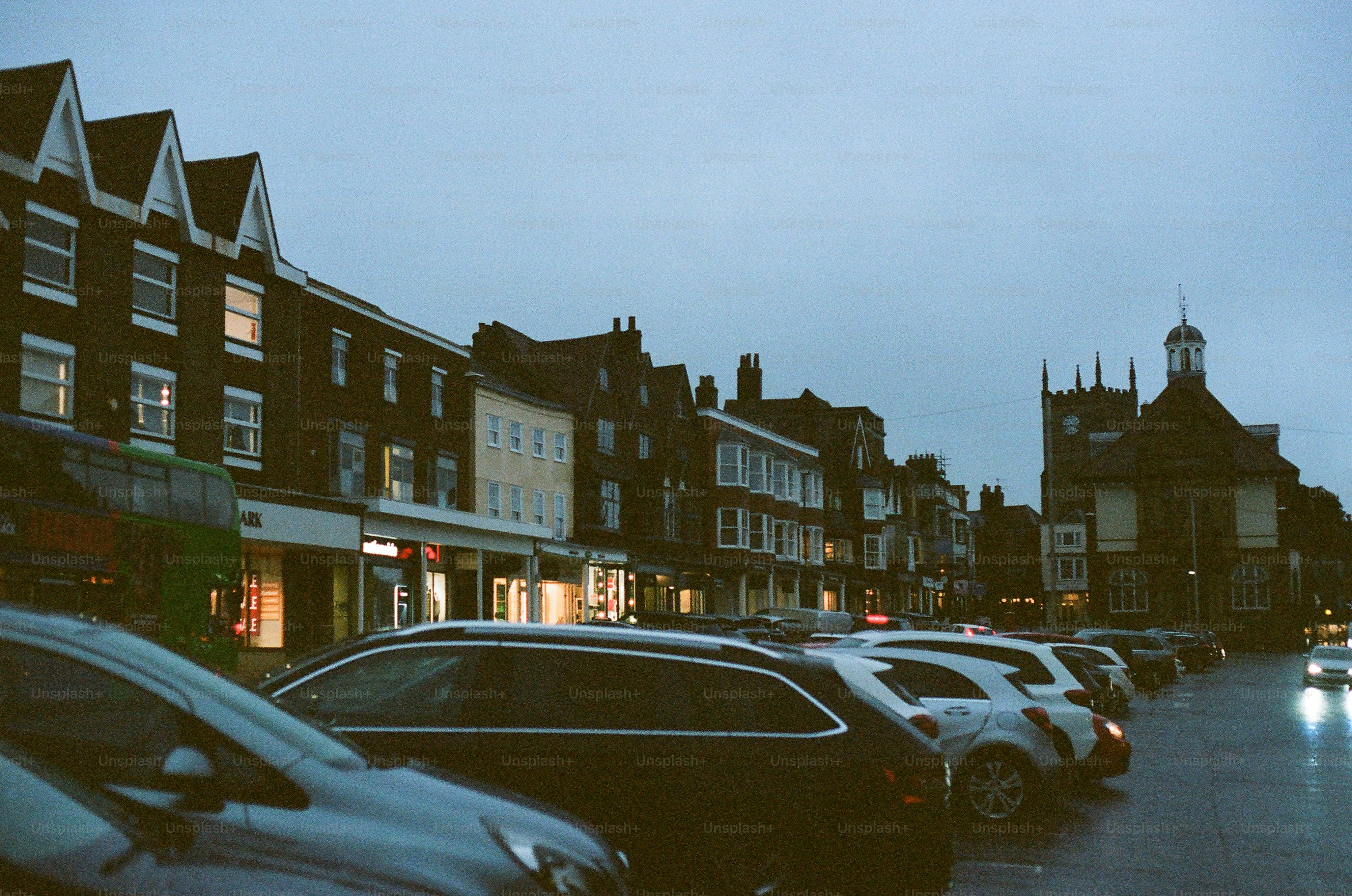 Cars parked on a street with buildings at dusk photo – Architecture ...