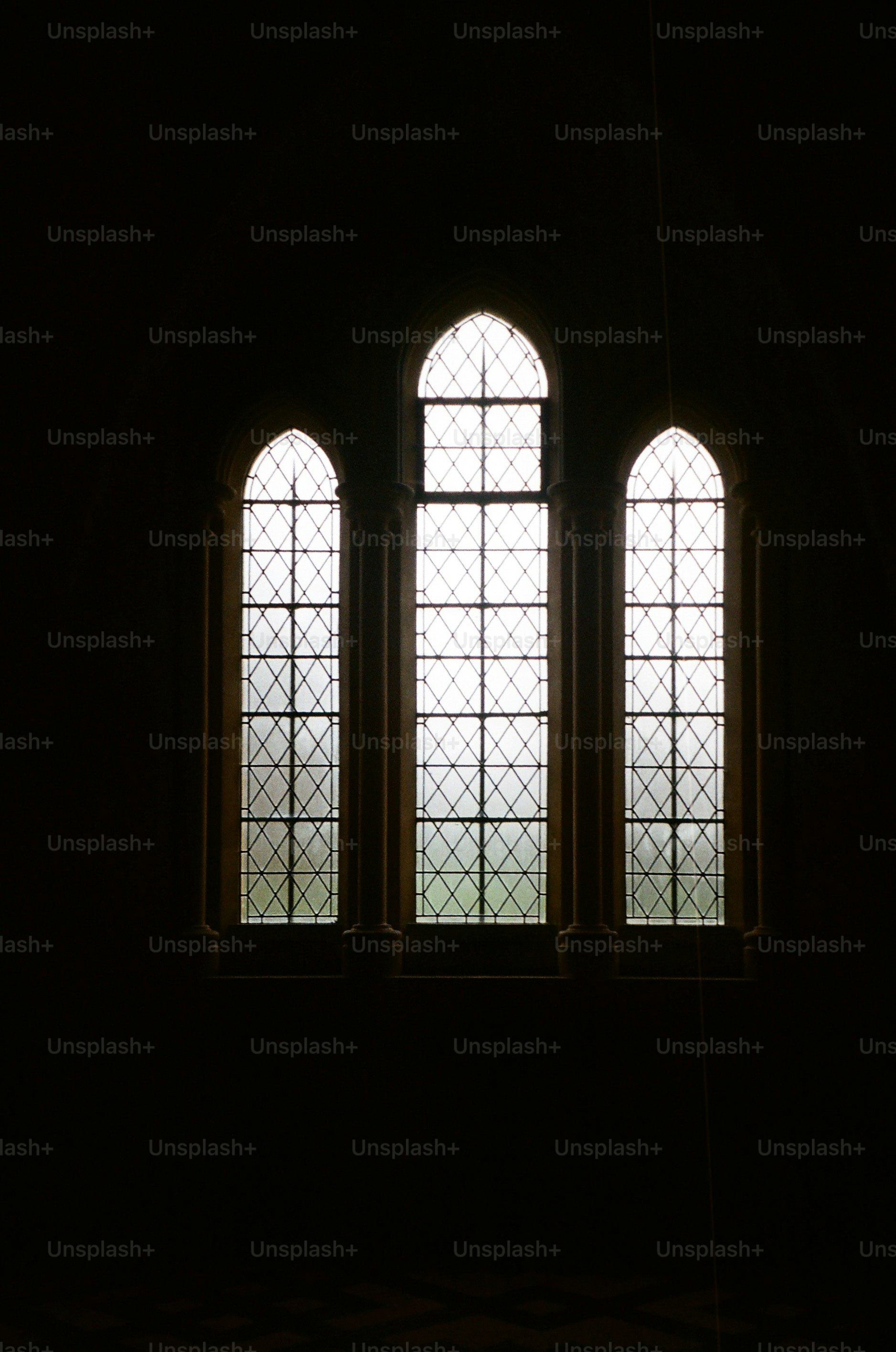 Three arched windows with diamond pane glass