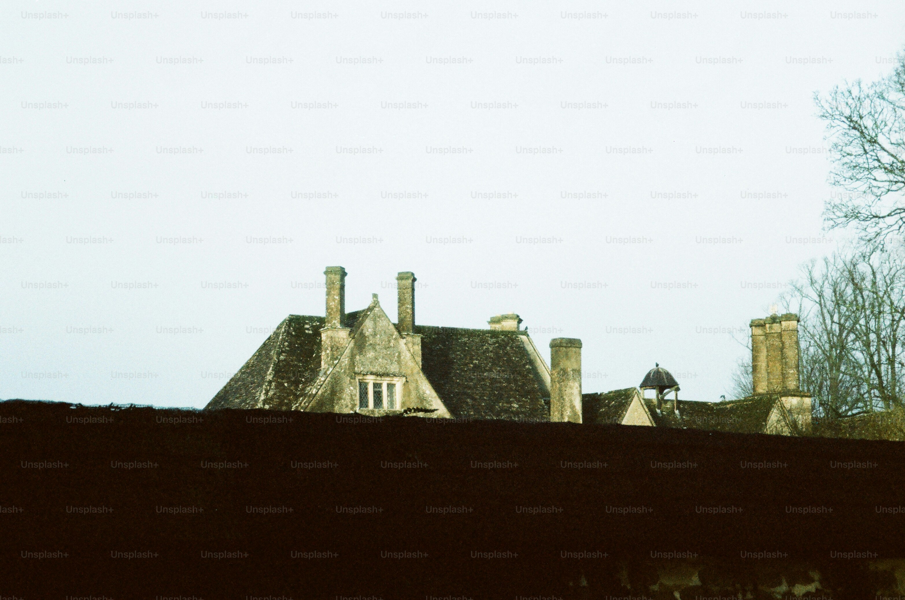 Um prédio de pedra com várias chaminés sob um céu cinzento.