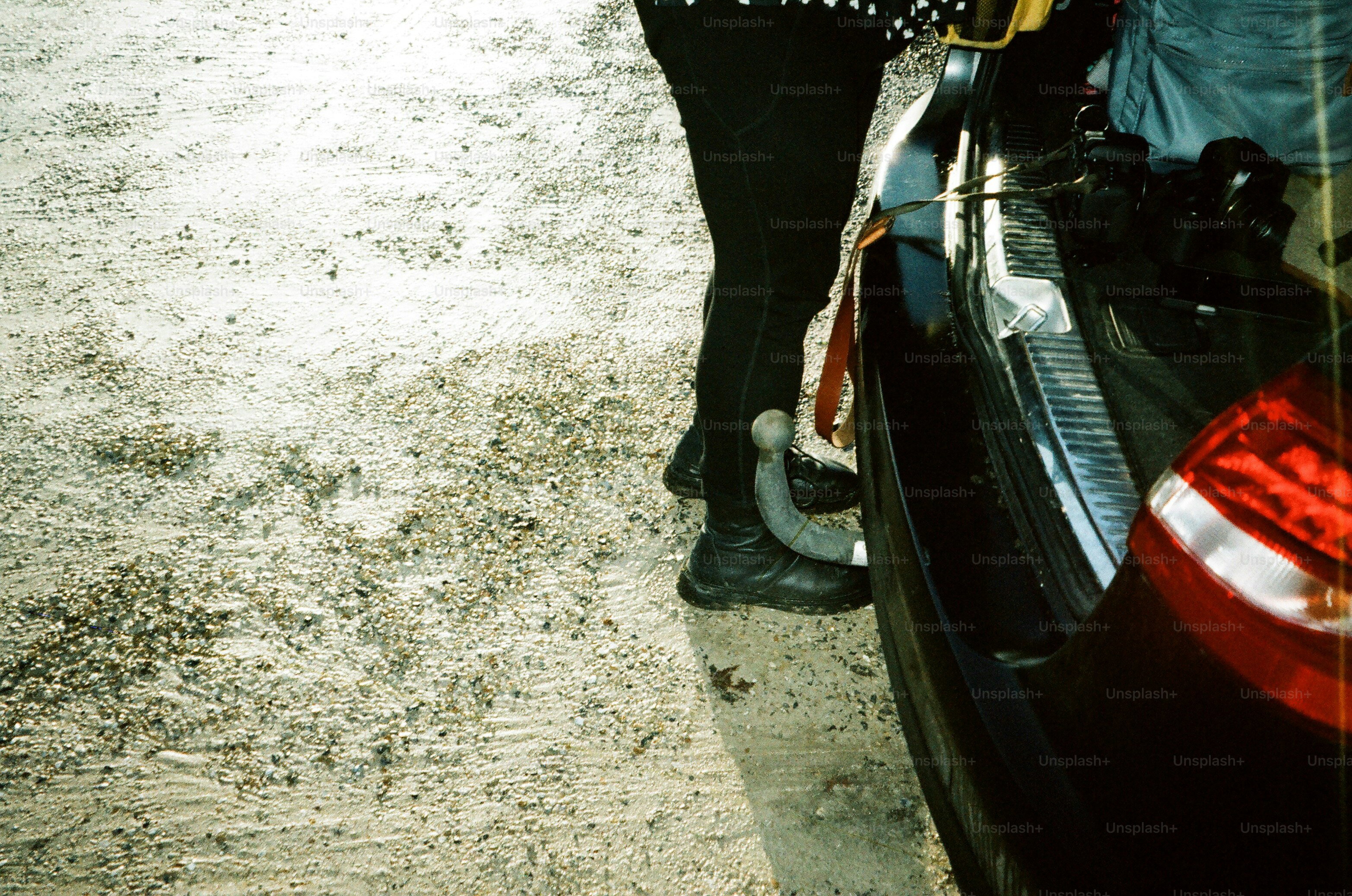 車のトランクの隣に立っている人が、トランクが開いている。