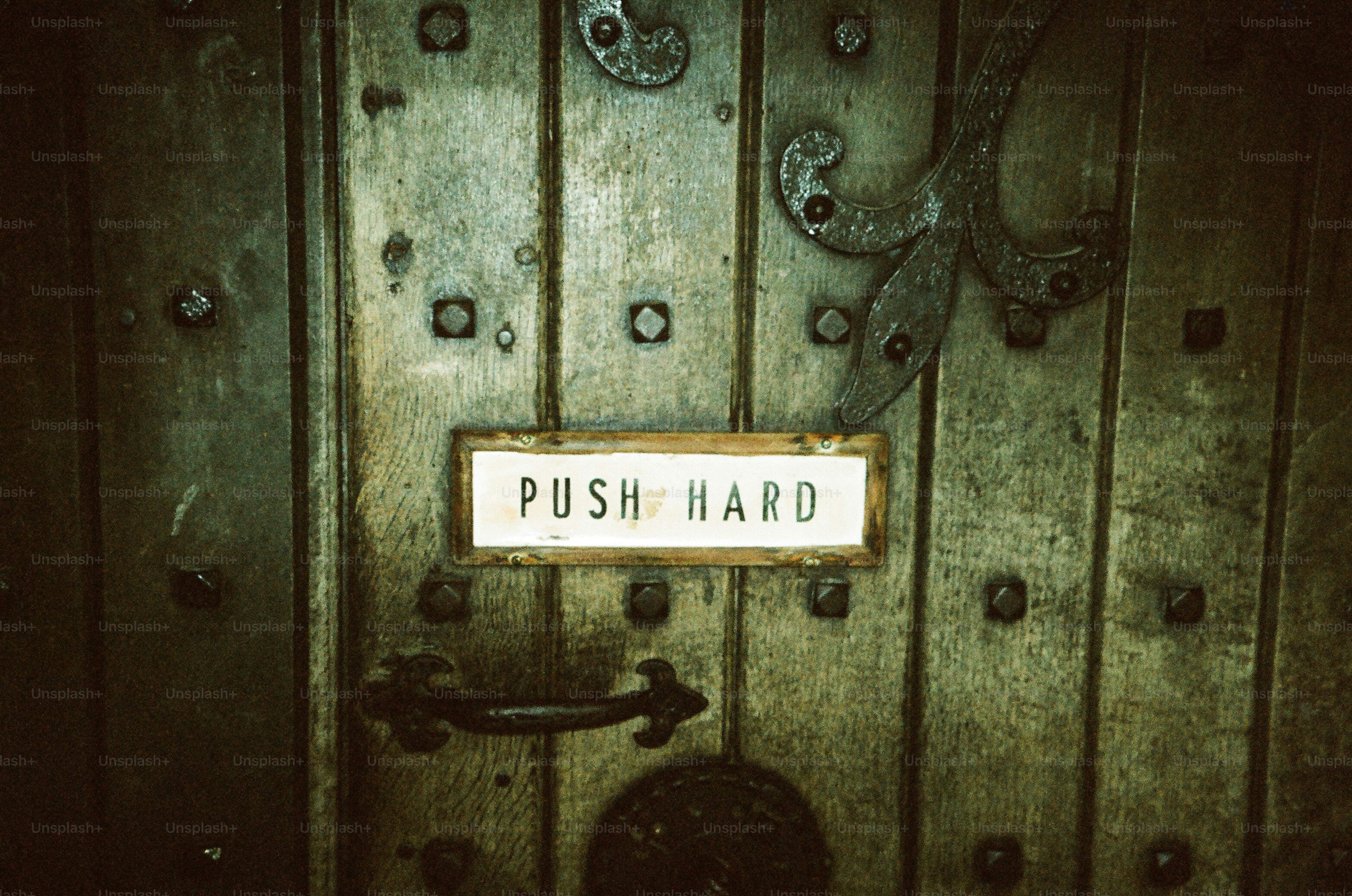 Wooden door with a "push hard" sign
