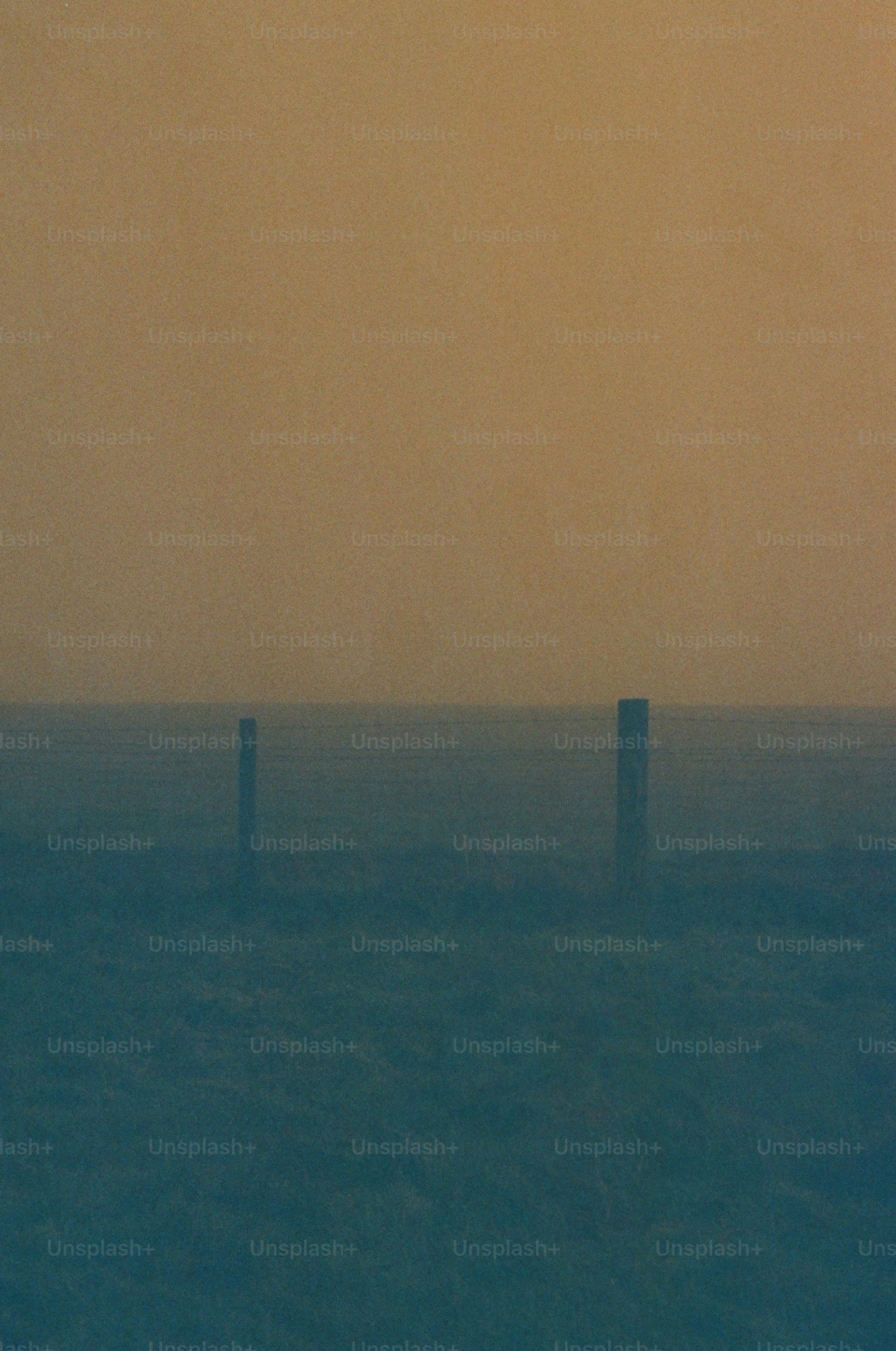 Two posts stand in a foggy, desolate landscape.