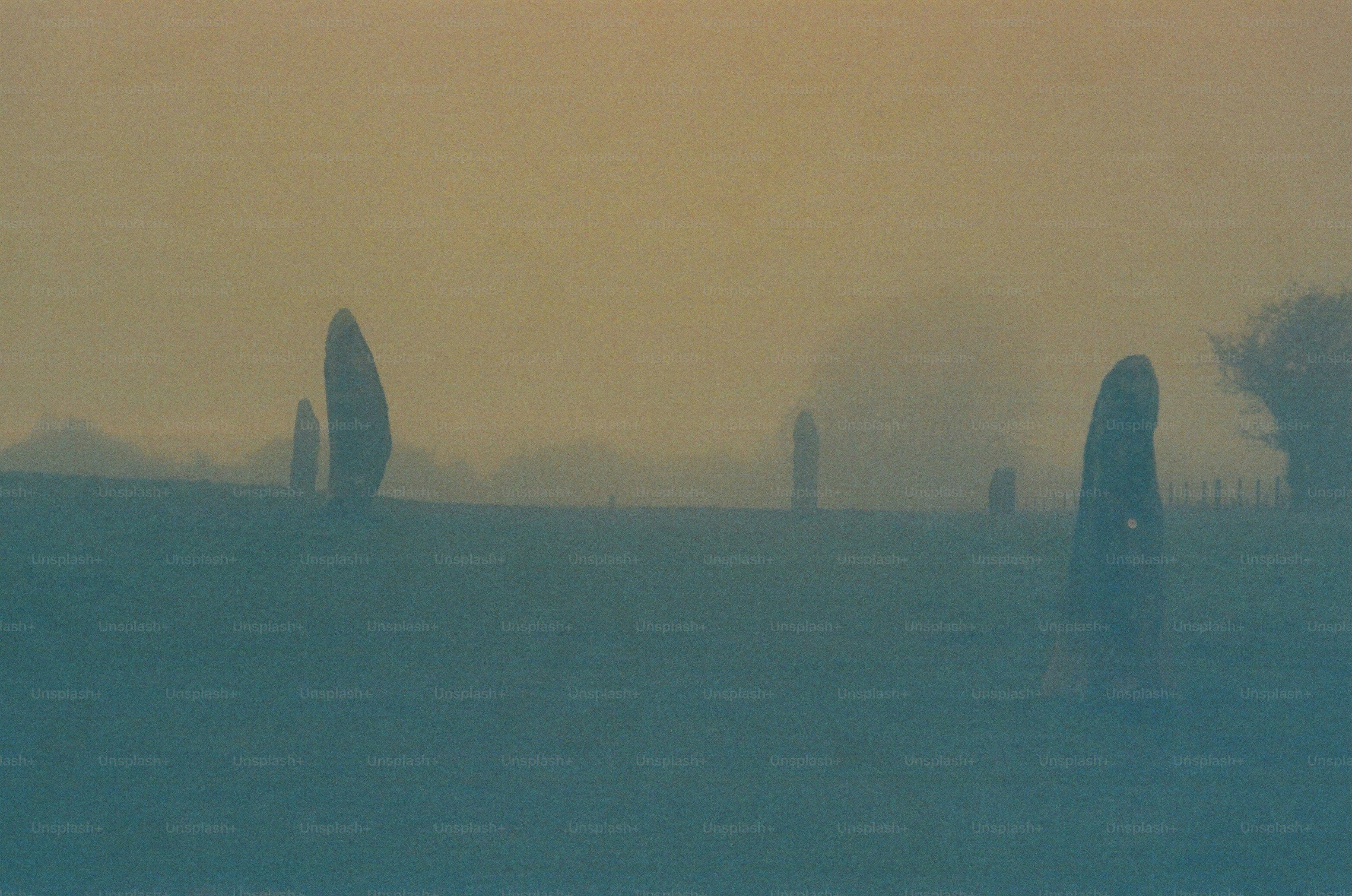 Standing stones in a misty field at sunrise