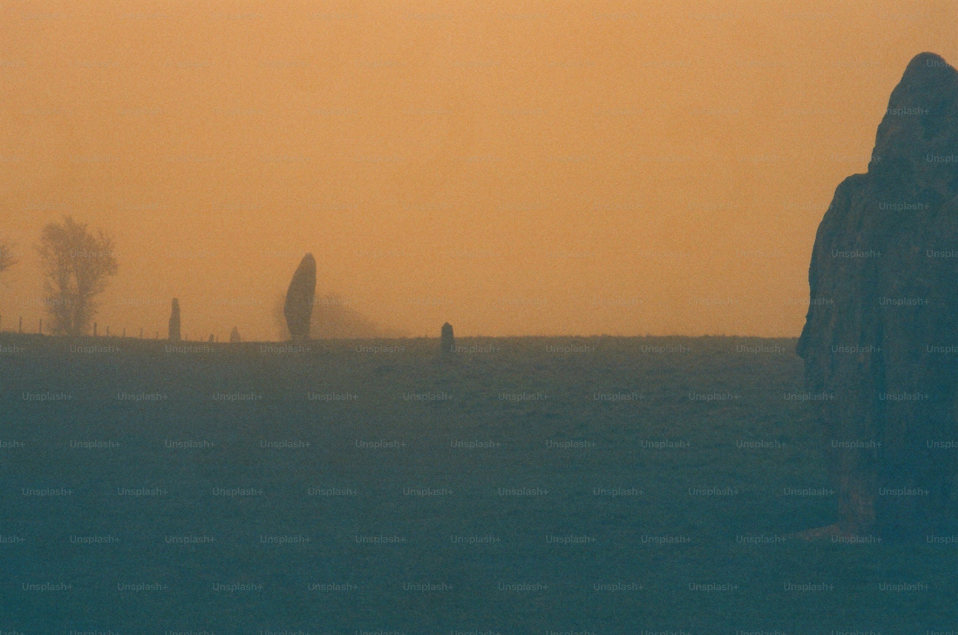 Misty field with standing stones at sunrise