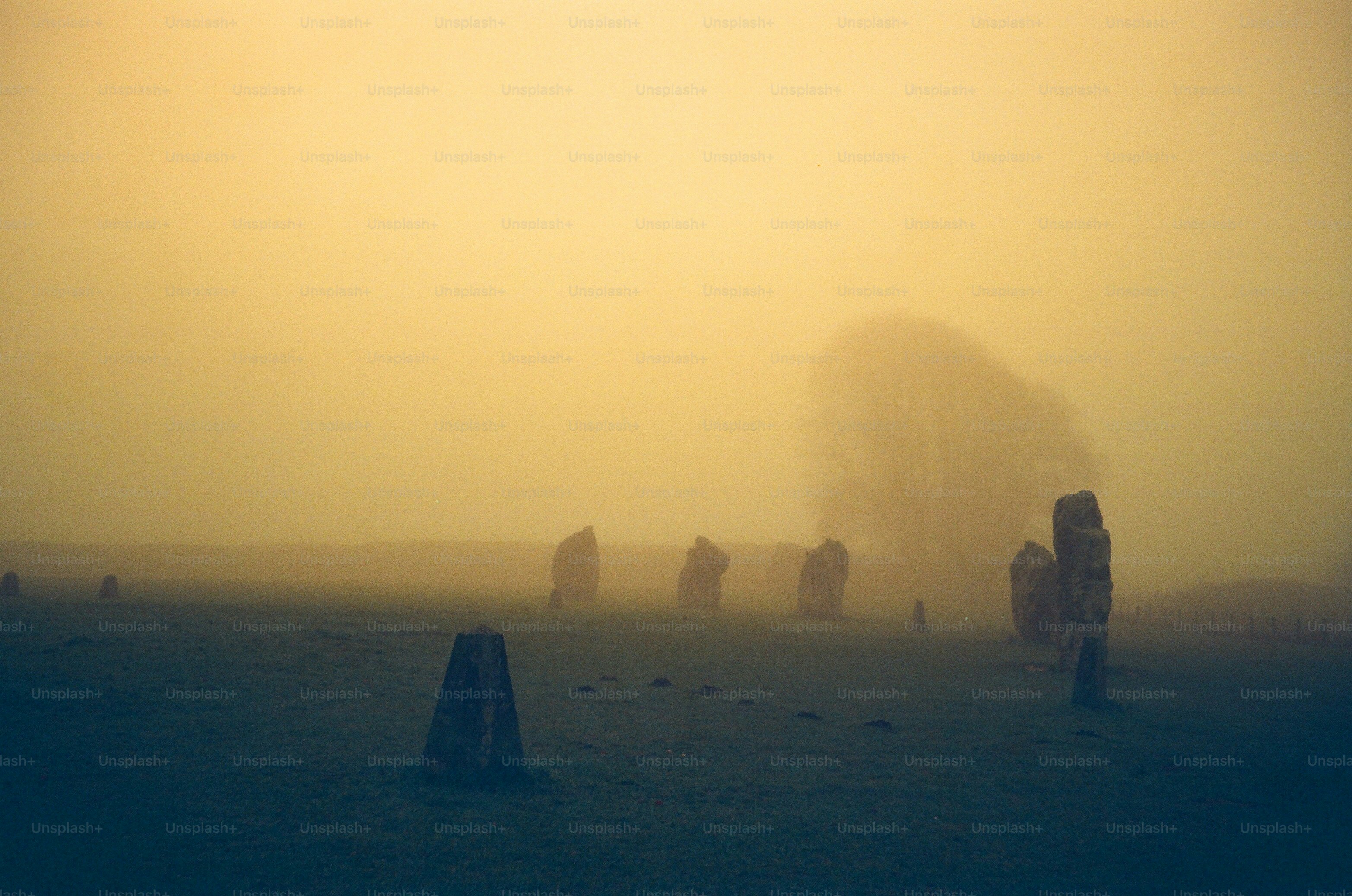 Misty field with standing stones at sunrise