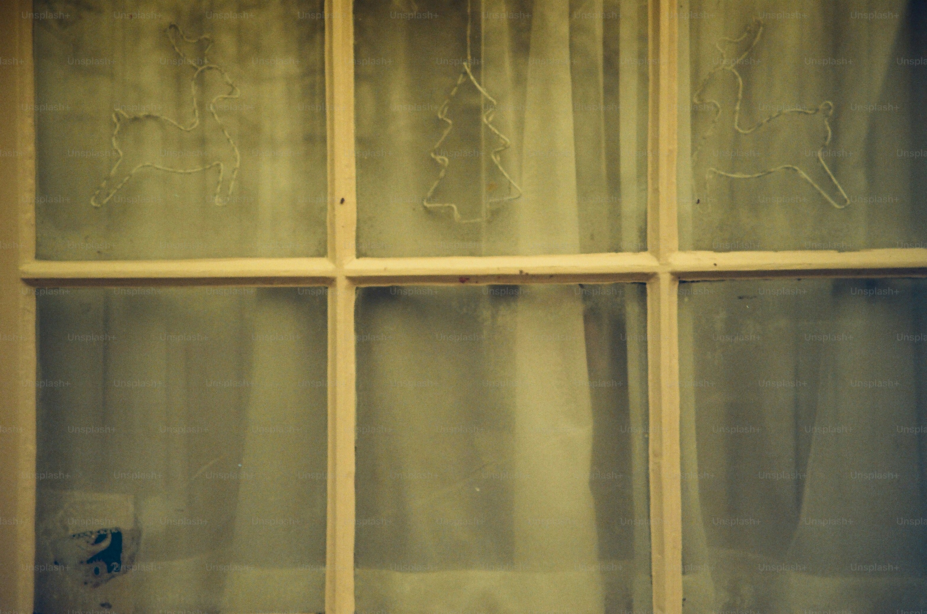 Frosted window with sheer white curtains behind