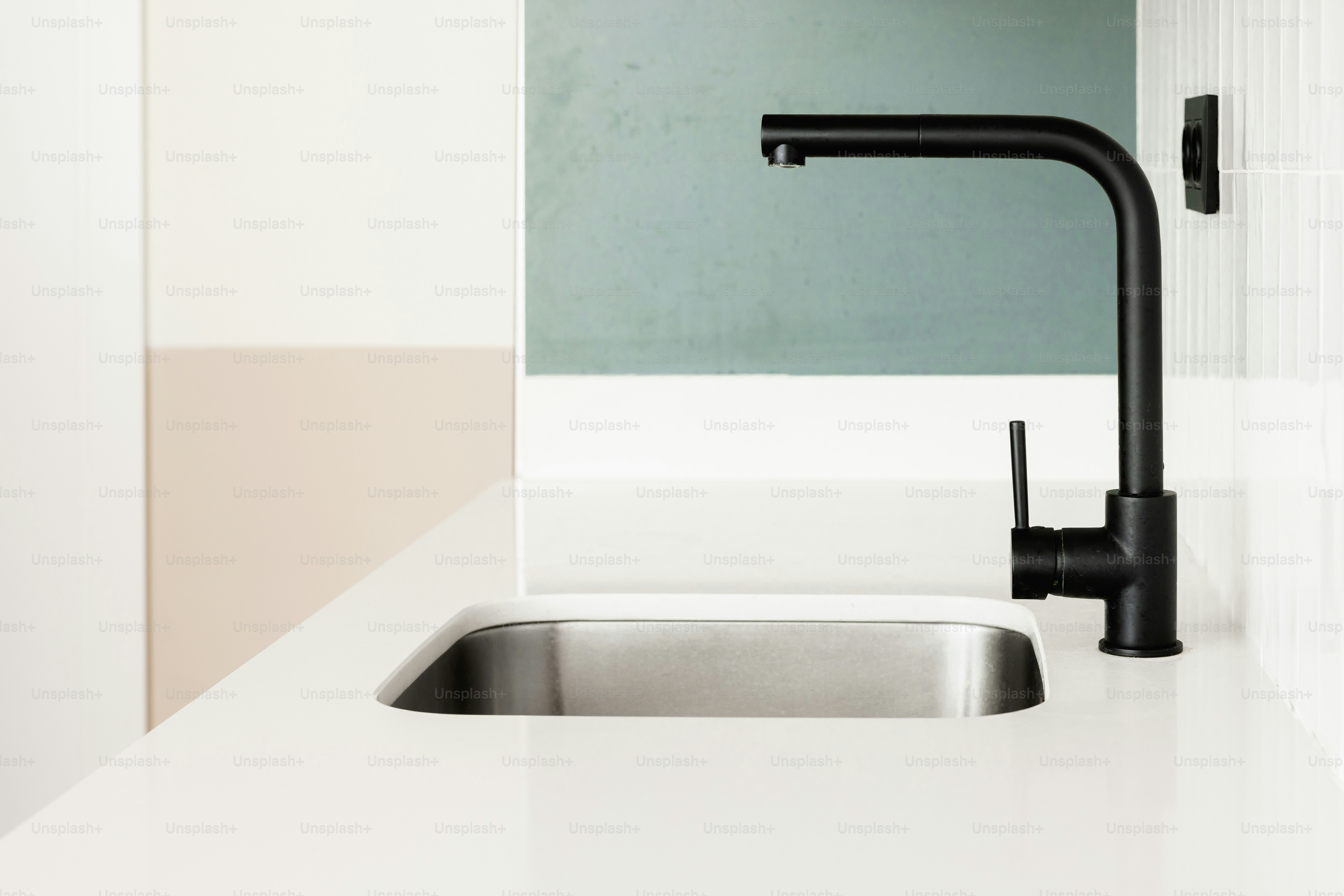 Grifo negro moderno sobre un fregadero de acero inoxidable.