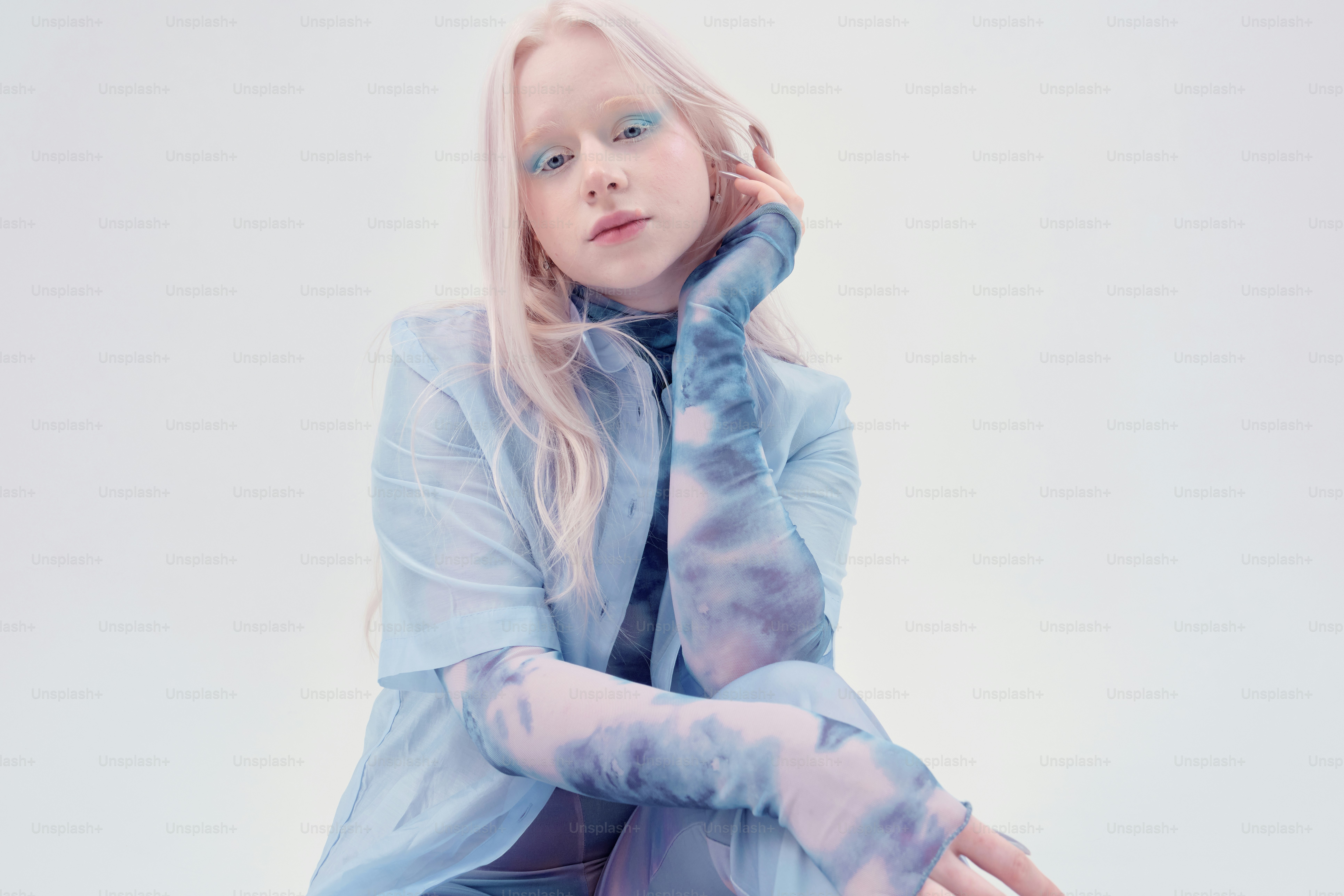 Young woman with pale skin and blonde hair wearing blue