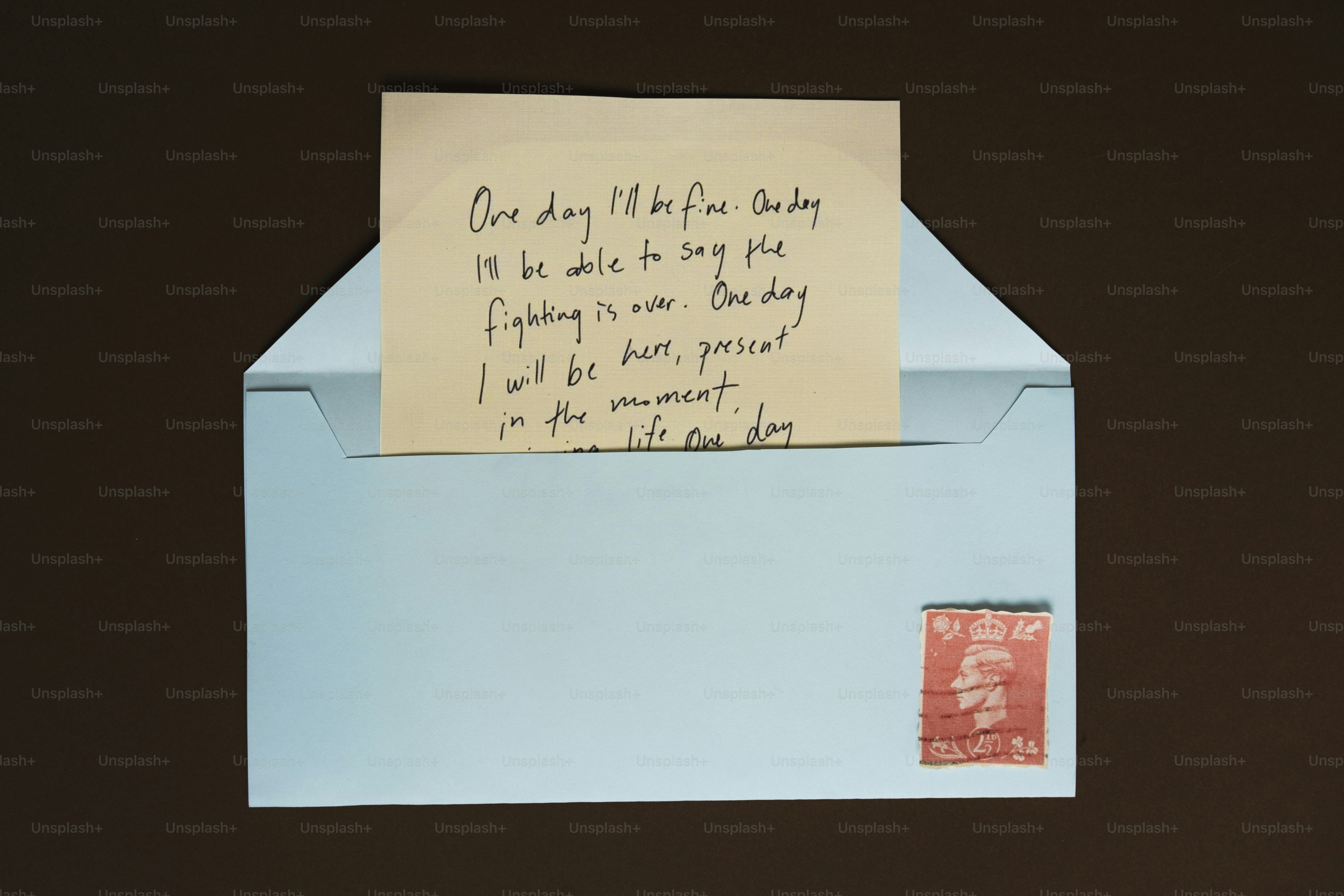 A handwritten note peeking out of a light blue envelope.