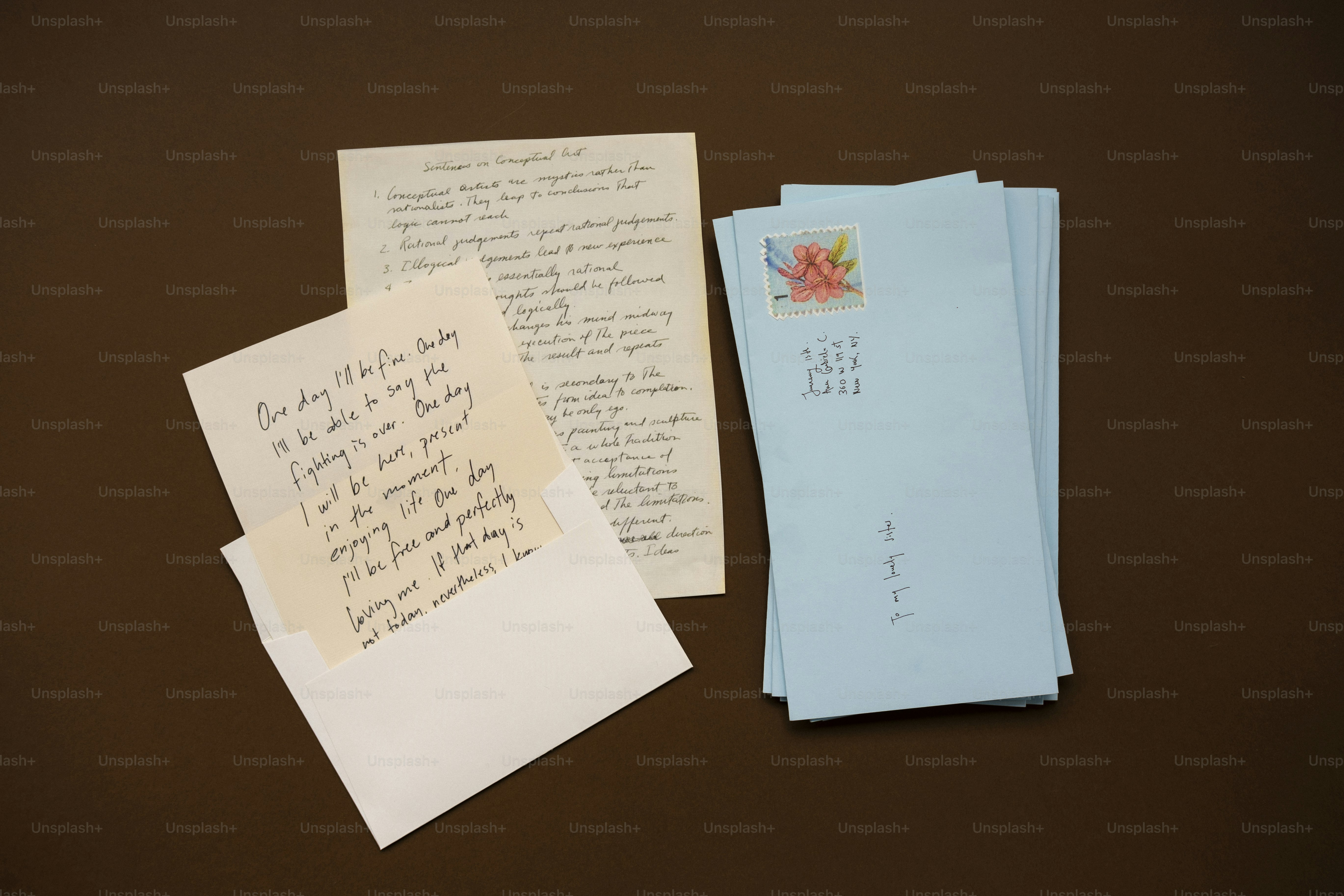 Cartas e envelopes dispostos sobre uma superfície marrom.