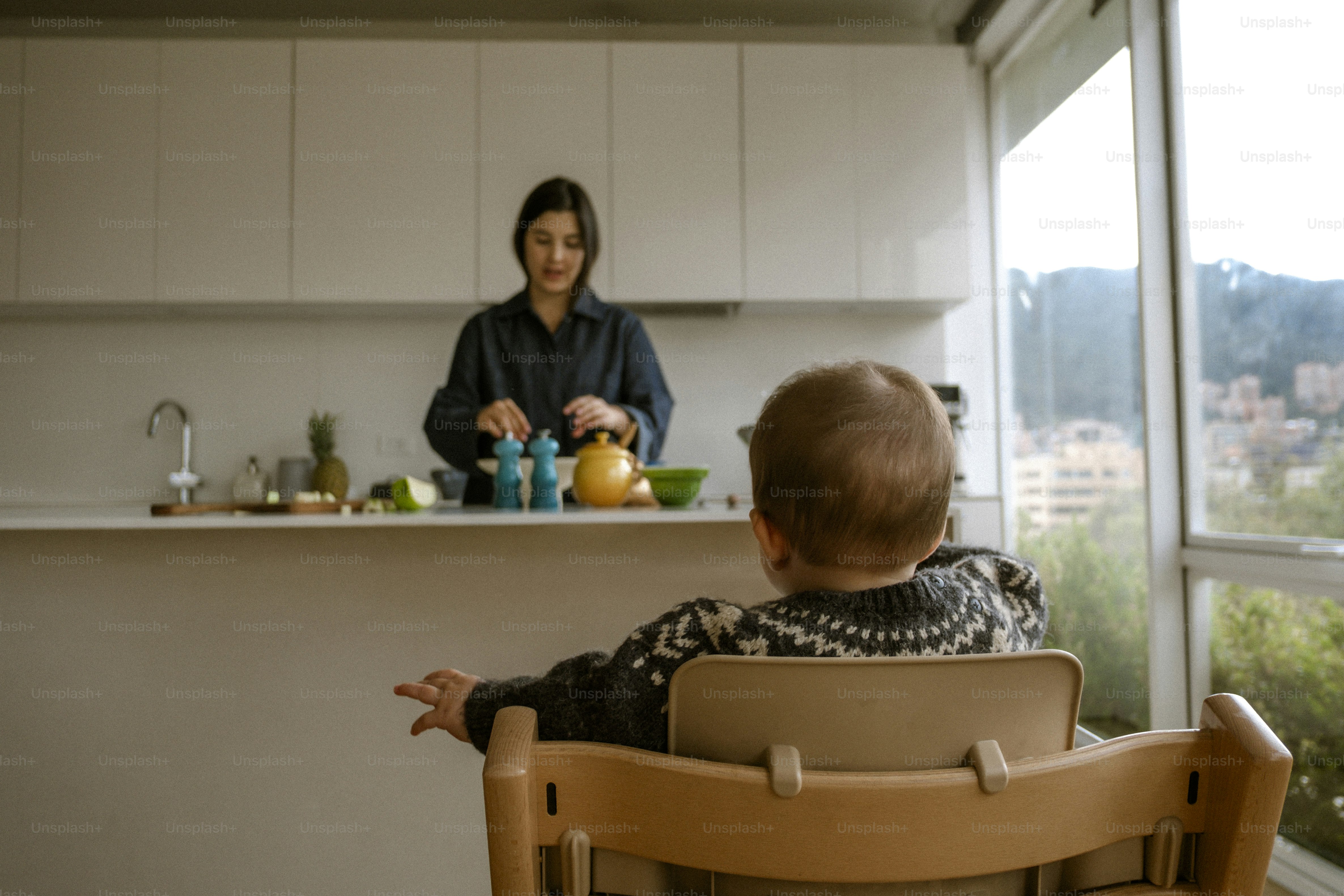 Woman preparing food while child watches in kitchen