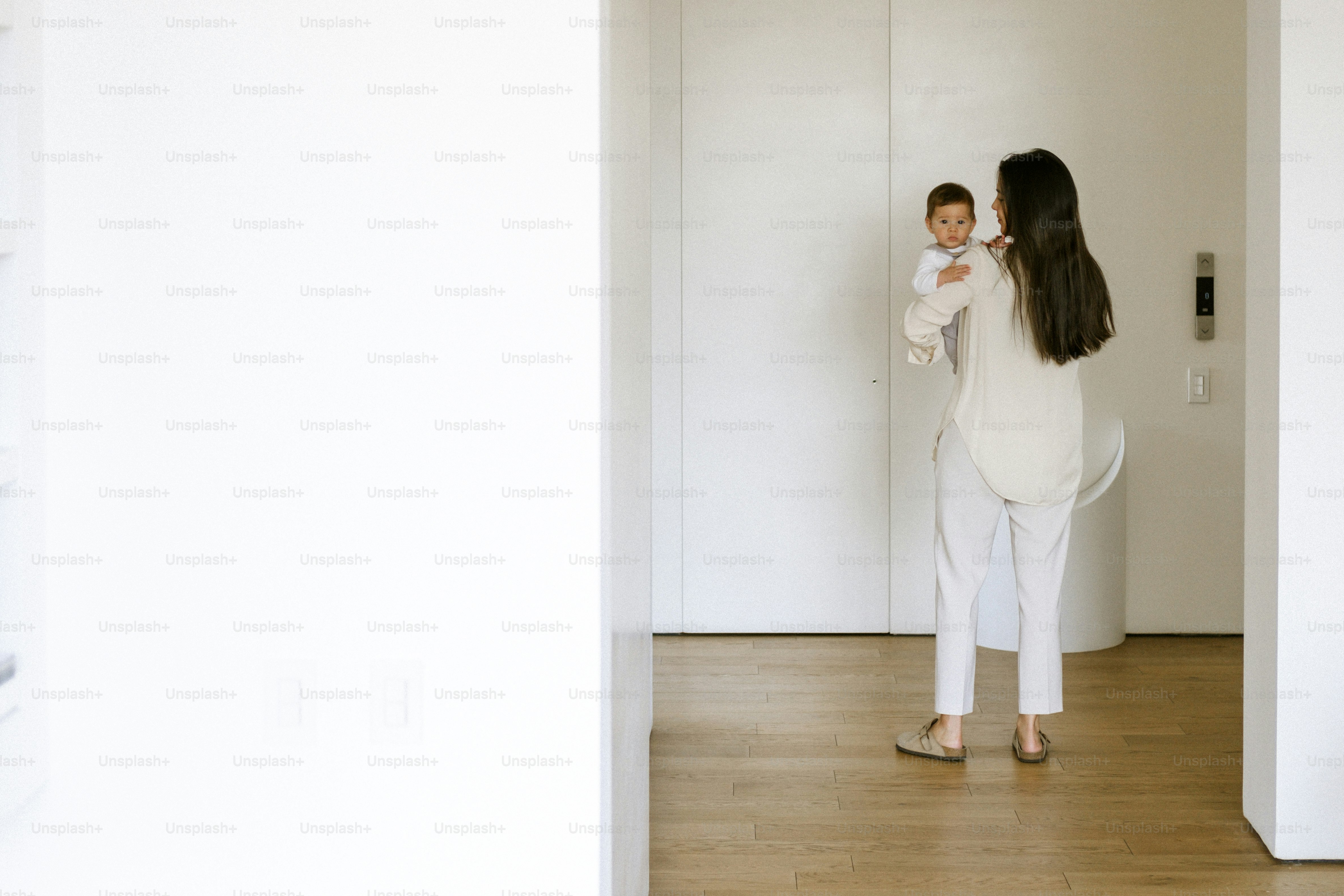 Woman holding a baby in a modern hallway