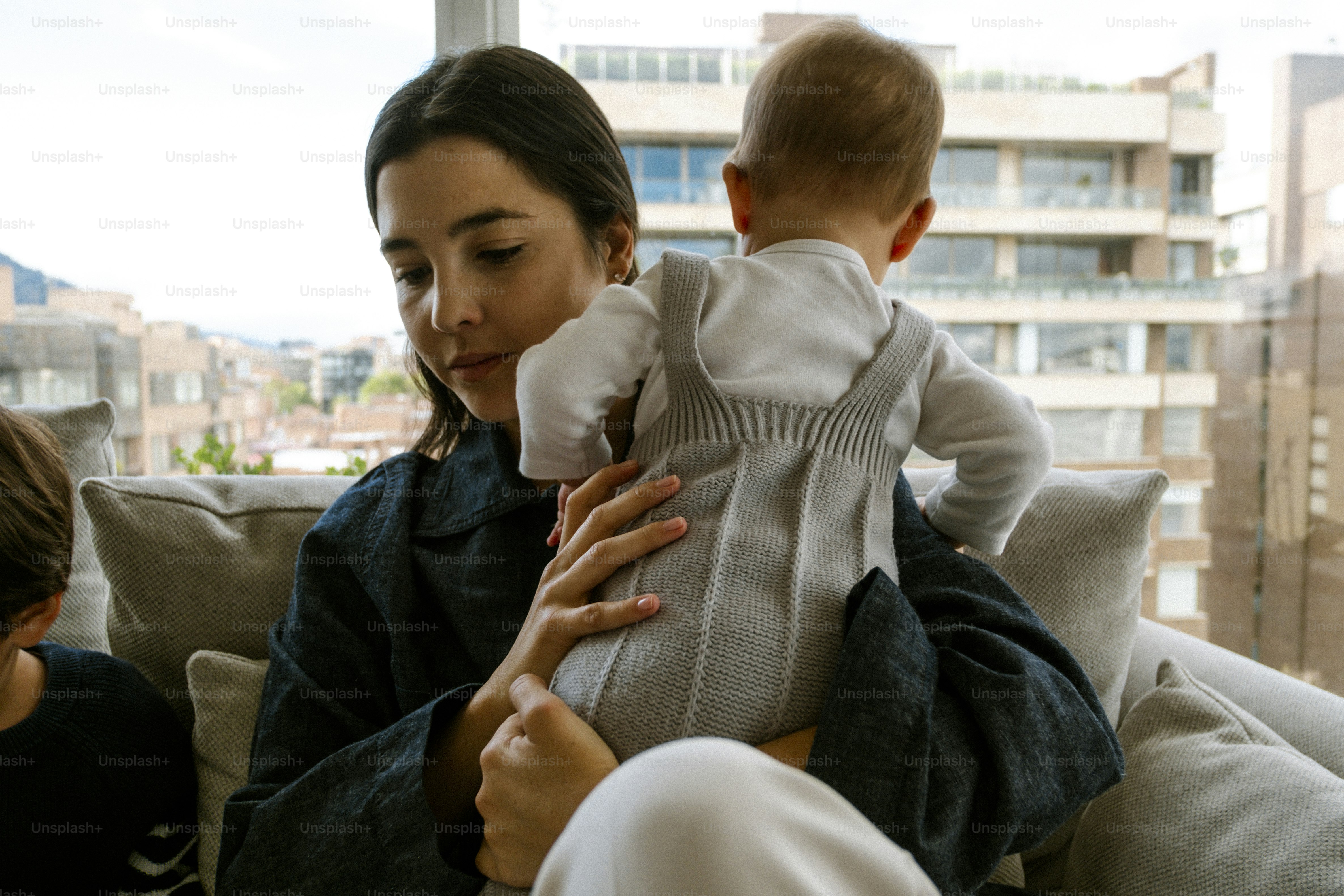 Mother holding her baby with a city view.