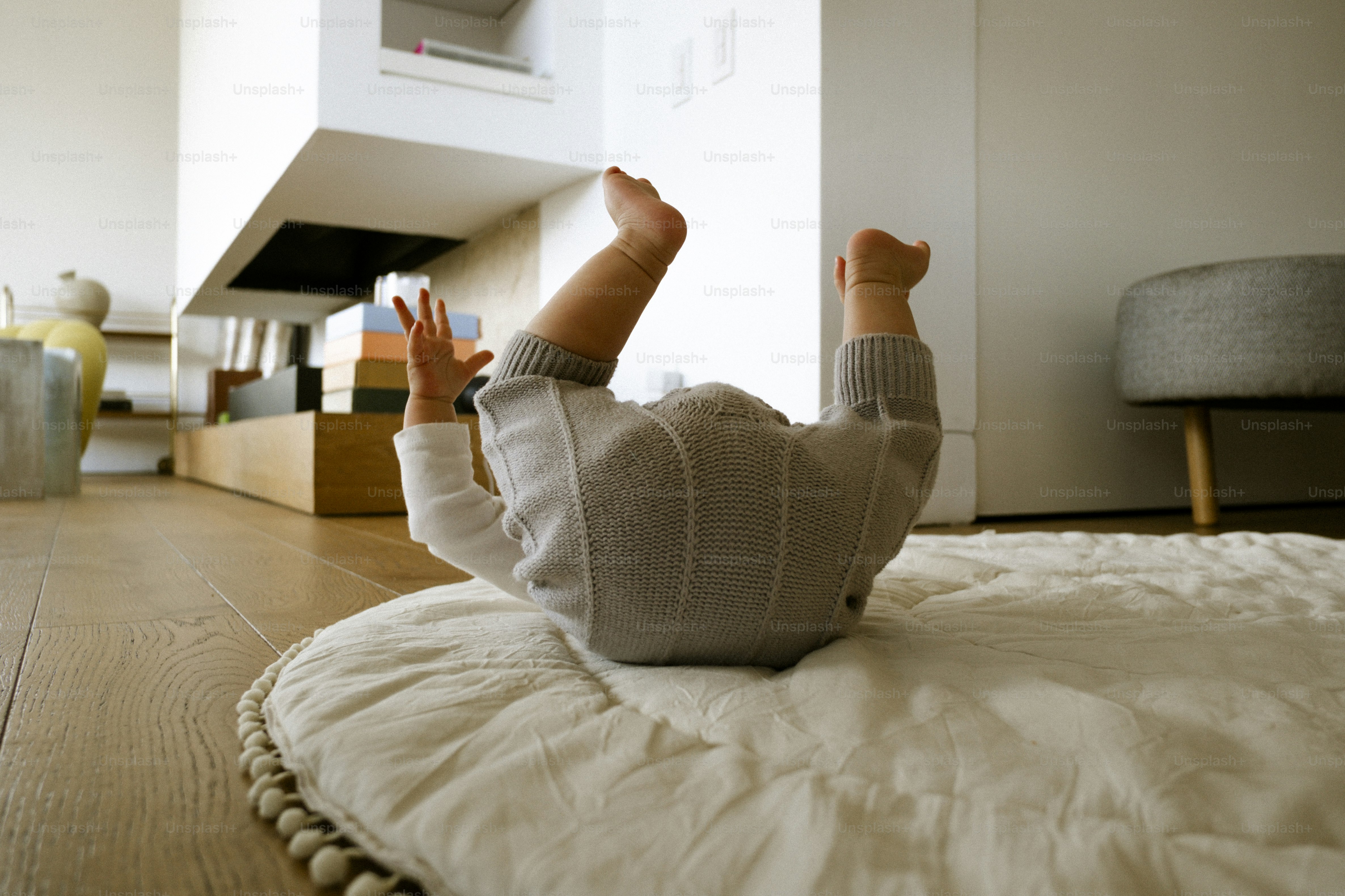 Baby rolling over on a mat indoors