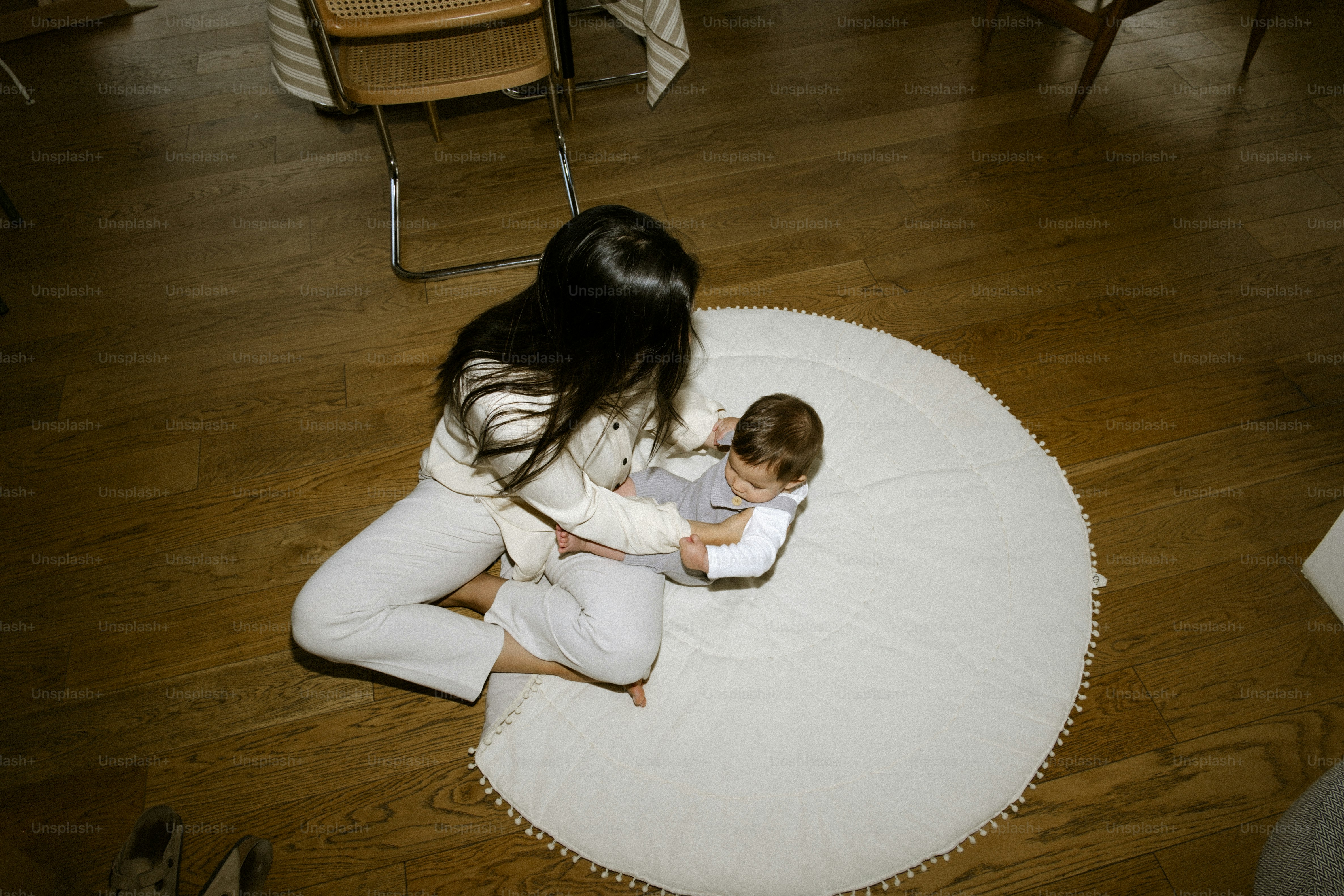 Woman and baby sitting on a round rug