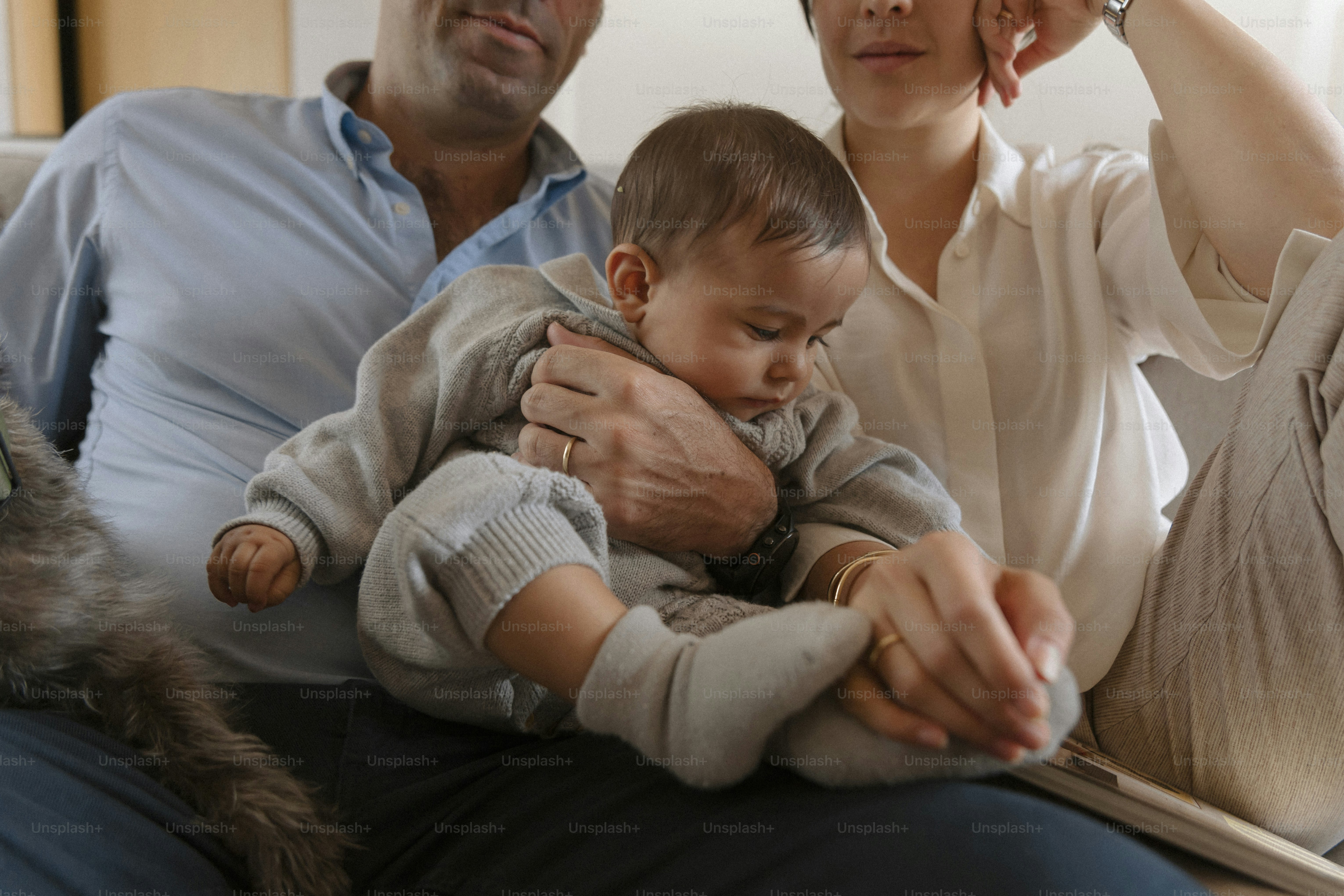 Parents holding their baby on the couch