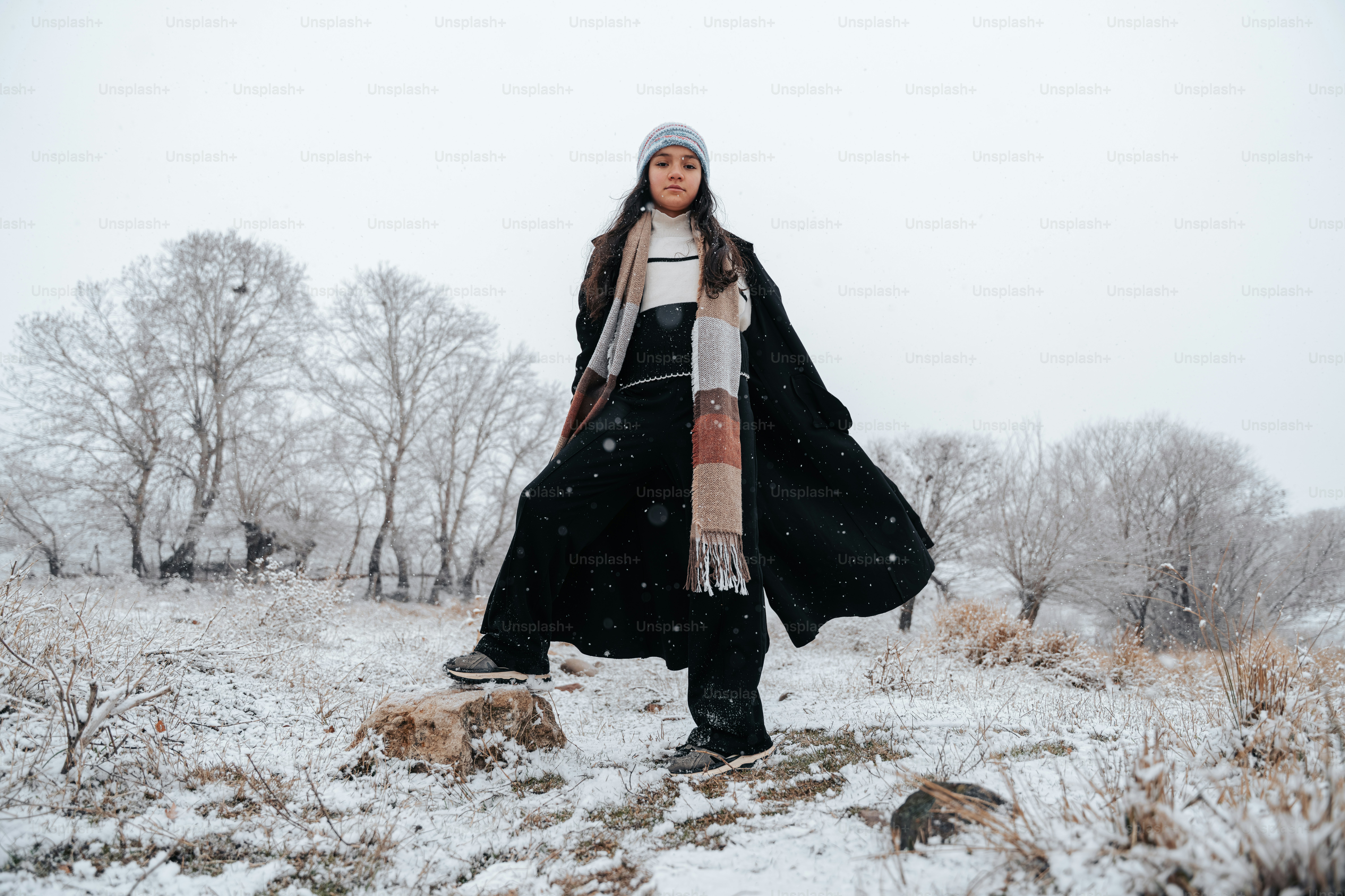 A person stands in a snowy landscape with trees.