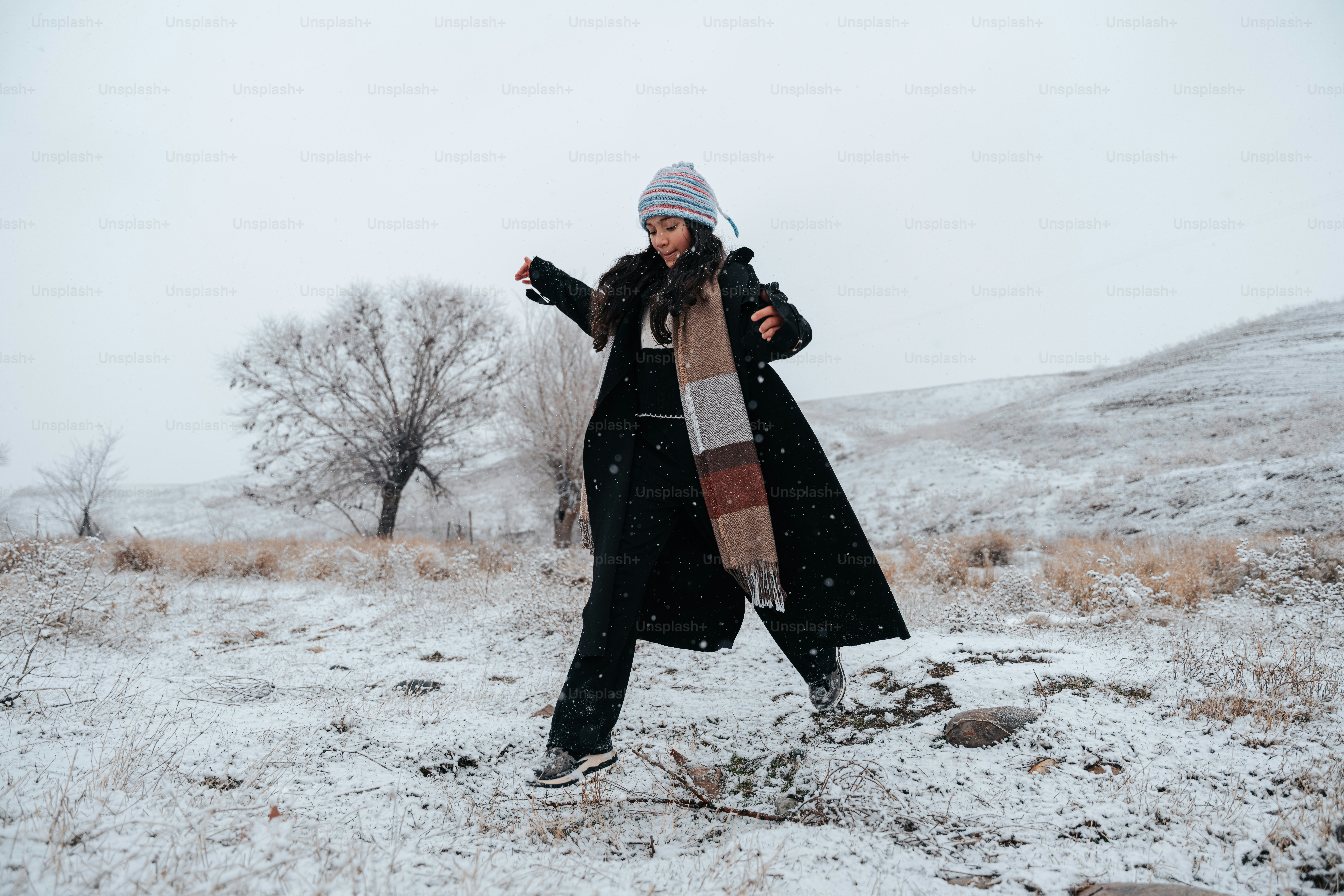 A woman in a coat walking in the snow photo – Fashion Image on Unsplash