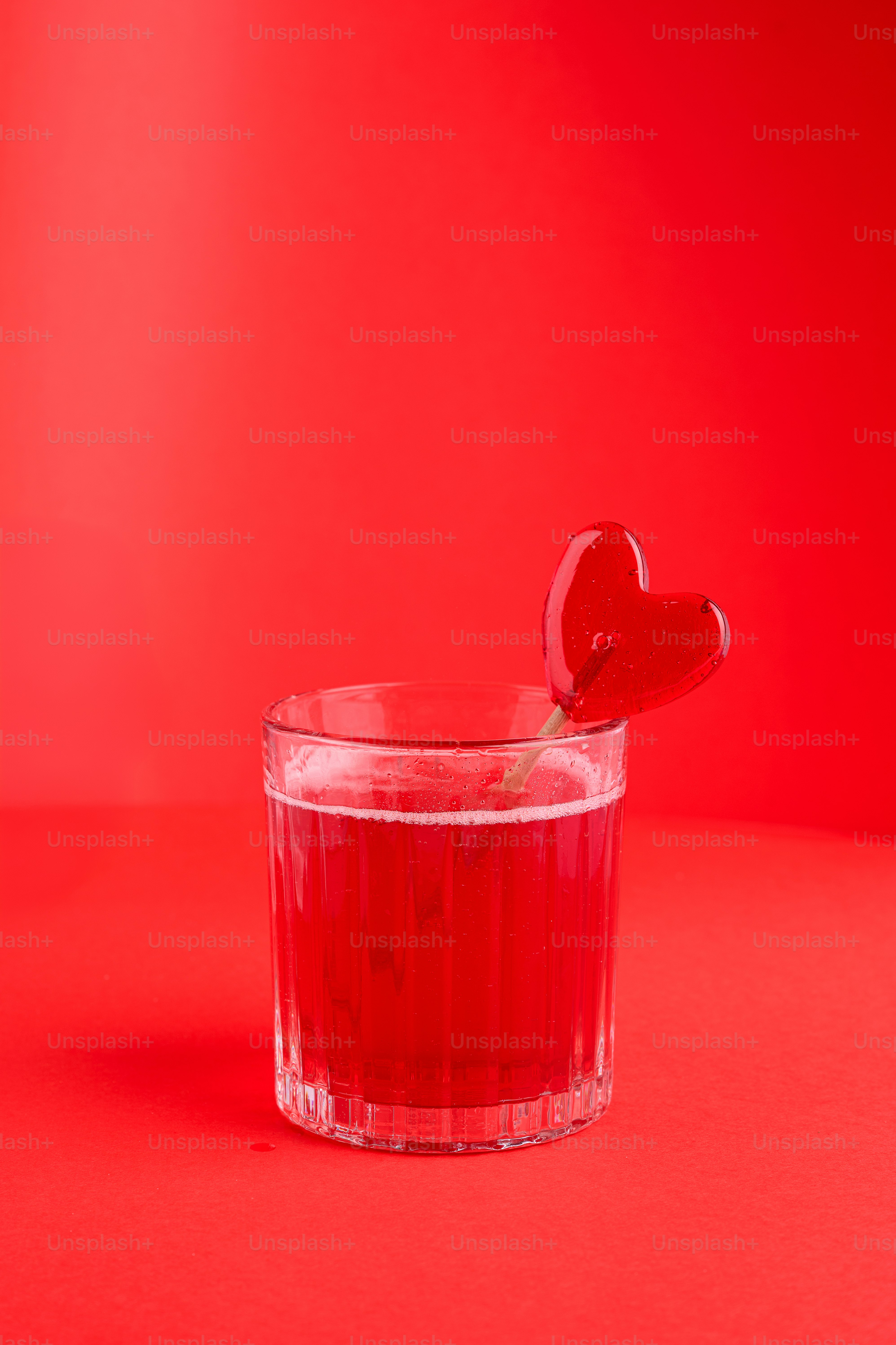 빨간 하트 롤리팝이 빨간 음료를 장식합니다.