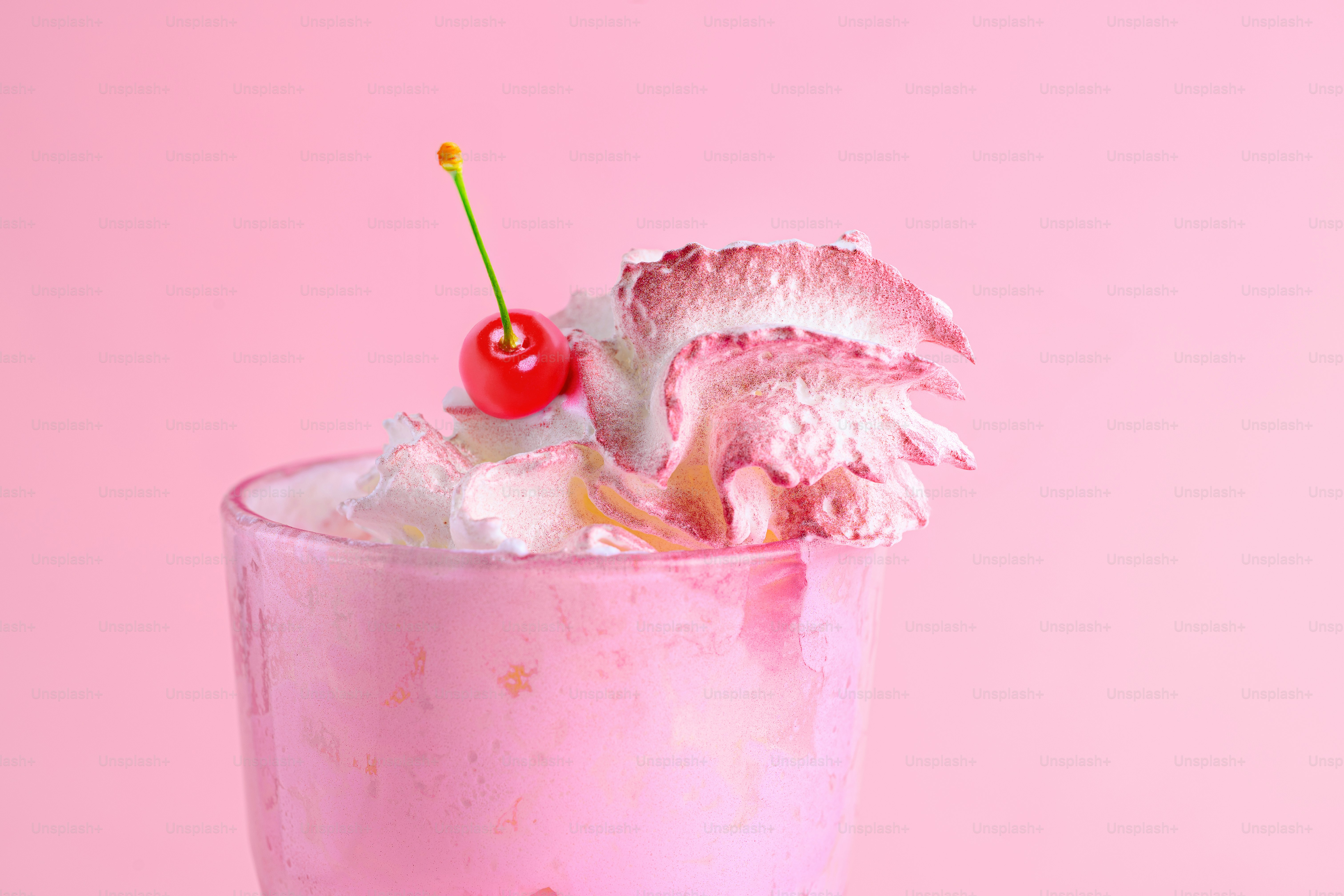 Milkshake rosa coberto com chantilly e cereja