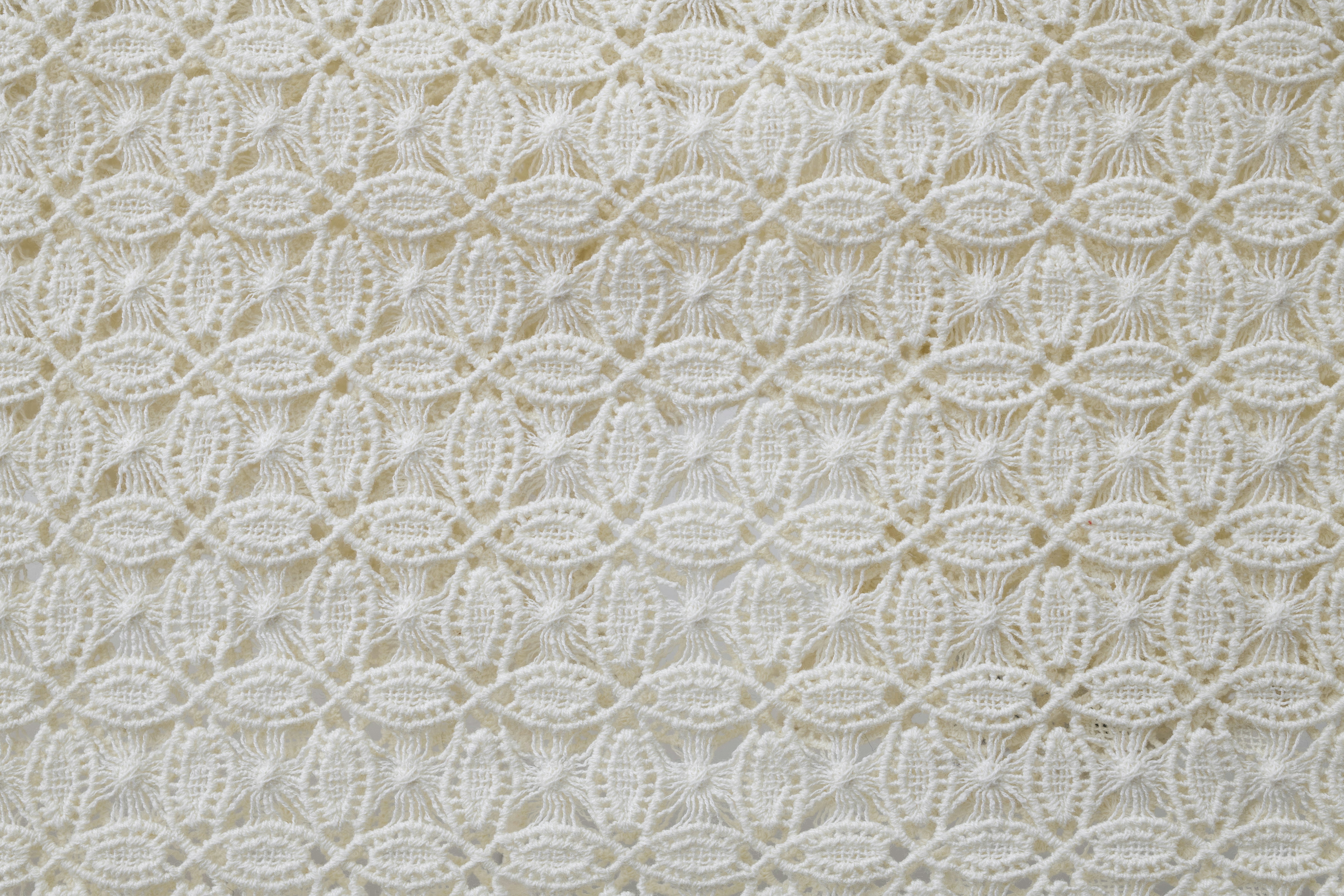 Gros plan d’un motif en dentelle blanche complexe