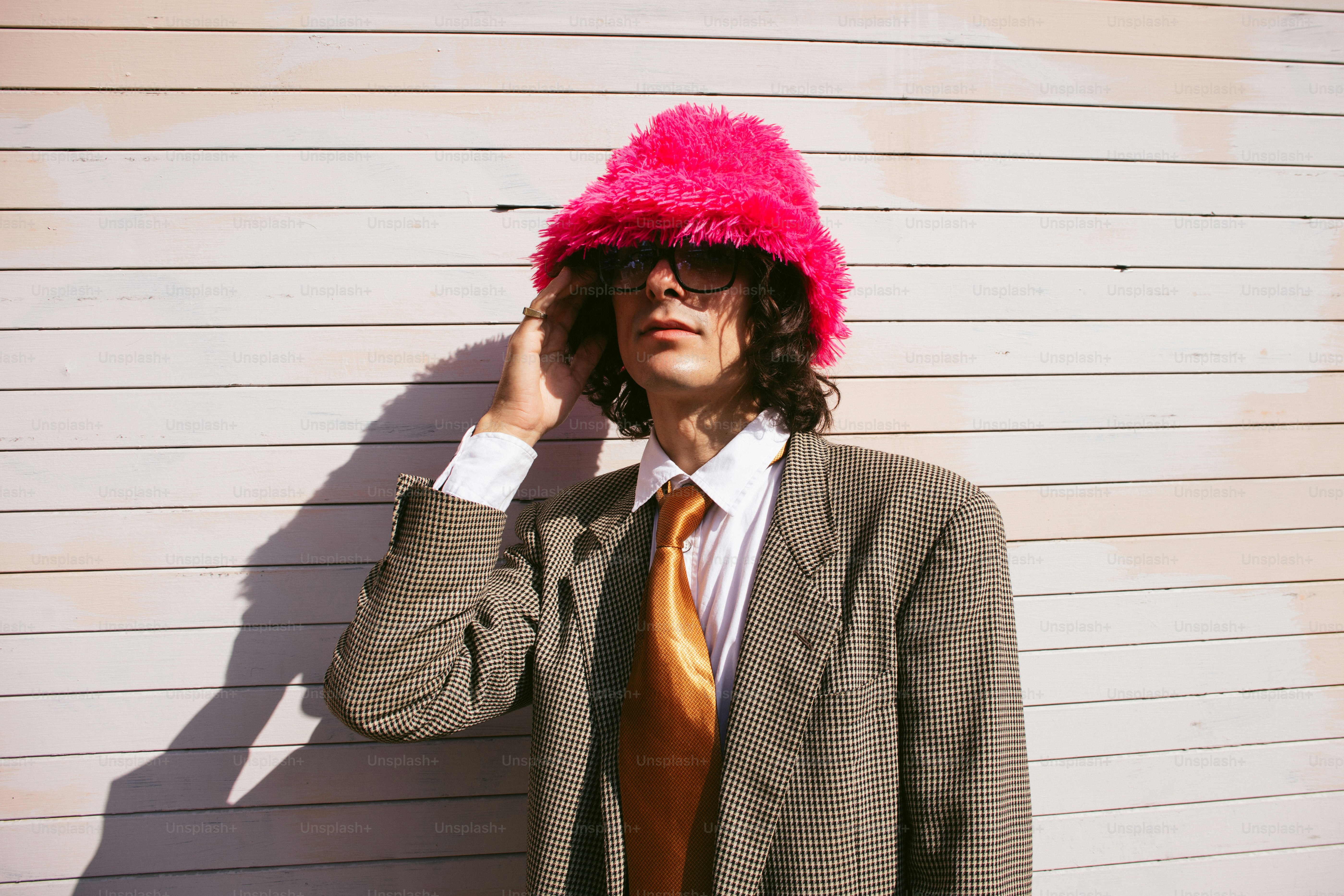 Homme en chapeau rose duveteux et costume