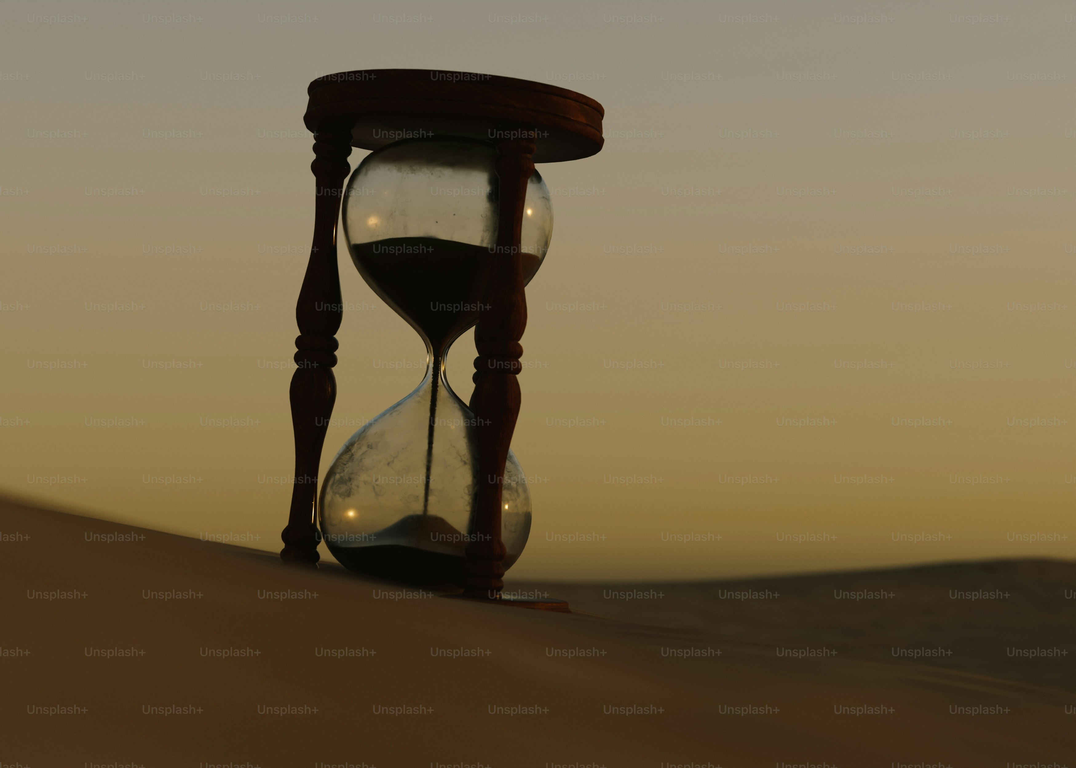 Hourglass in the sand at sunset