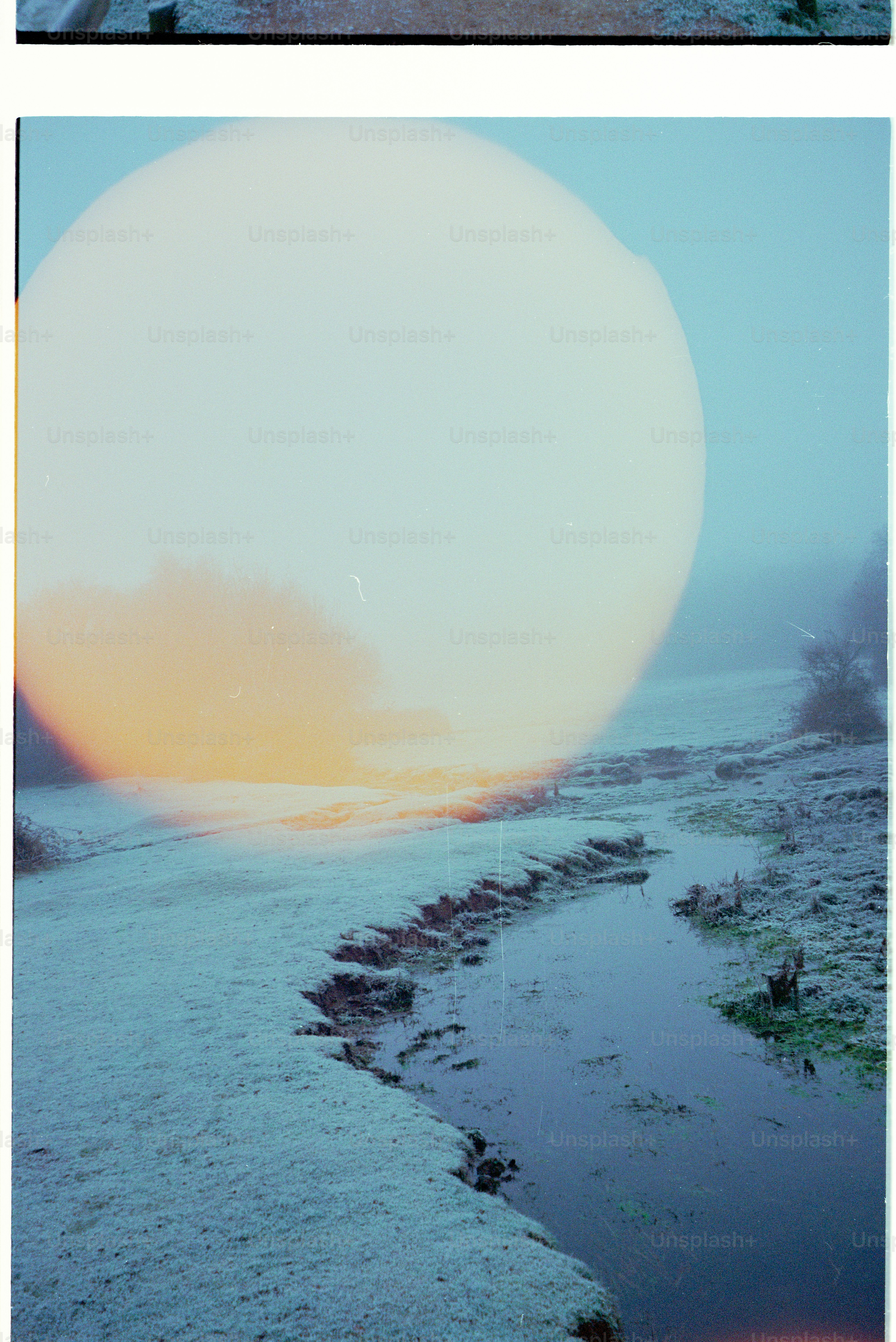A frosty landscape with a winding stream and large orb. photo – Winter ...