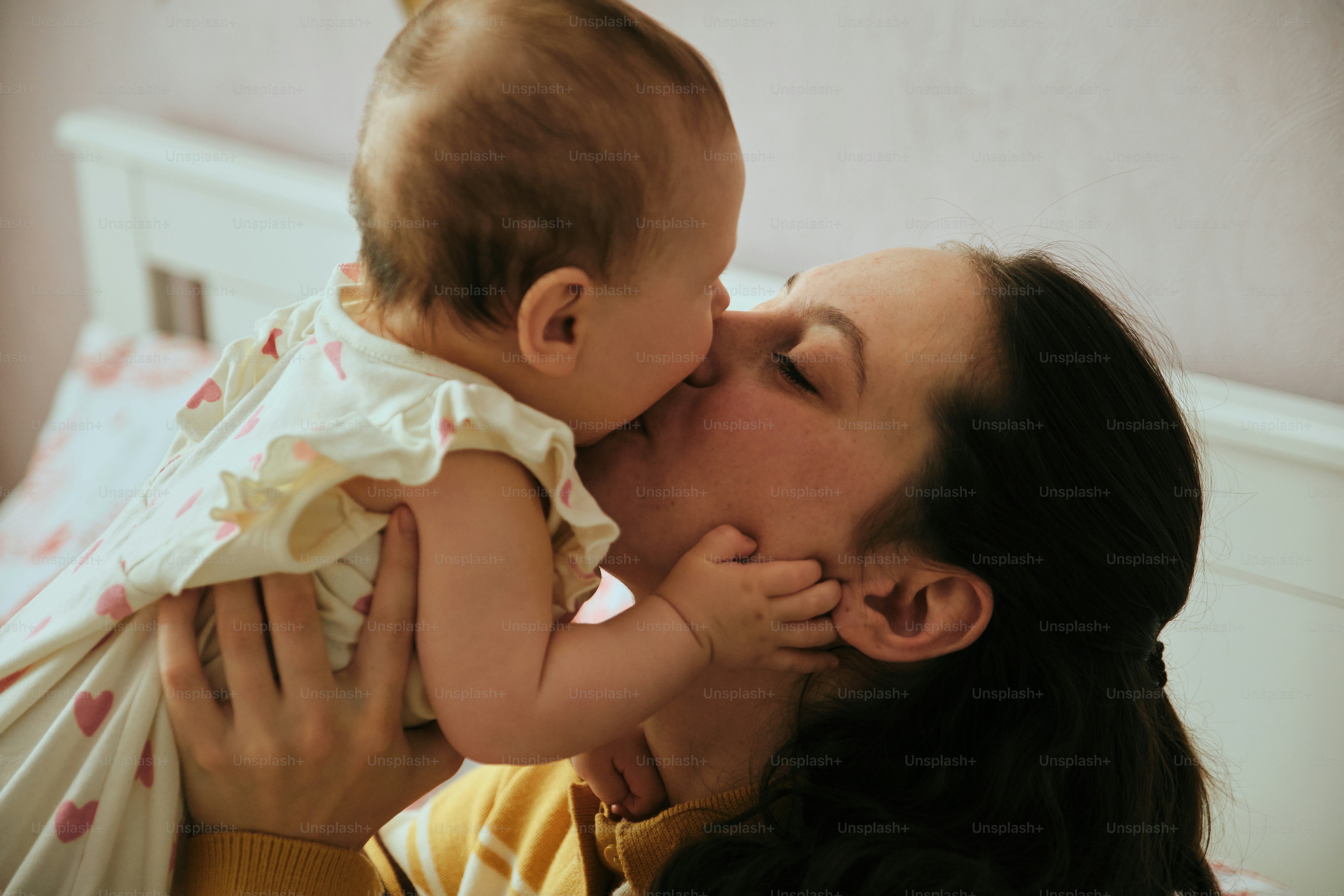 Mother kissing her baby with love and affection