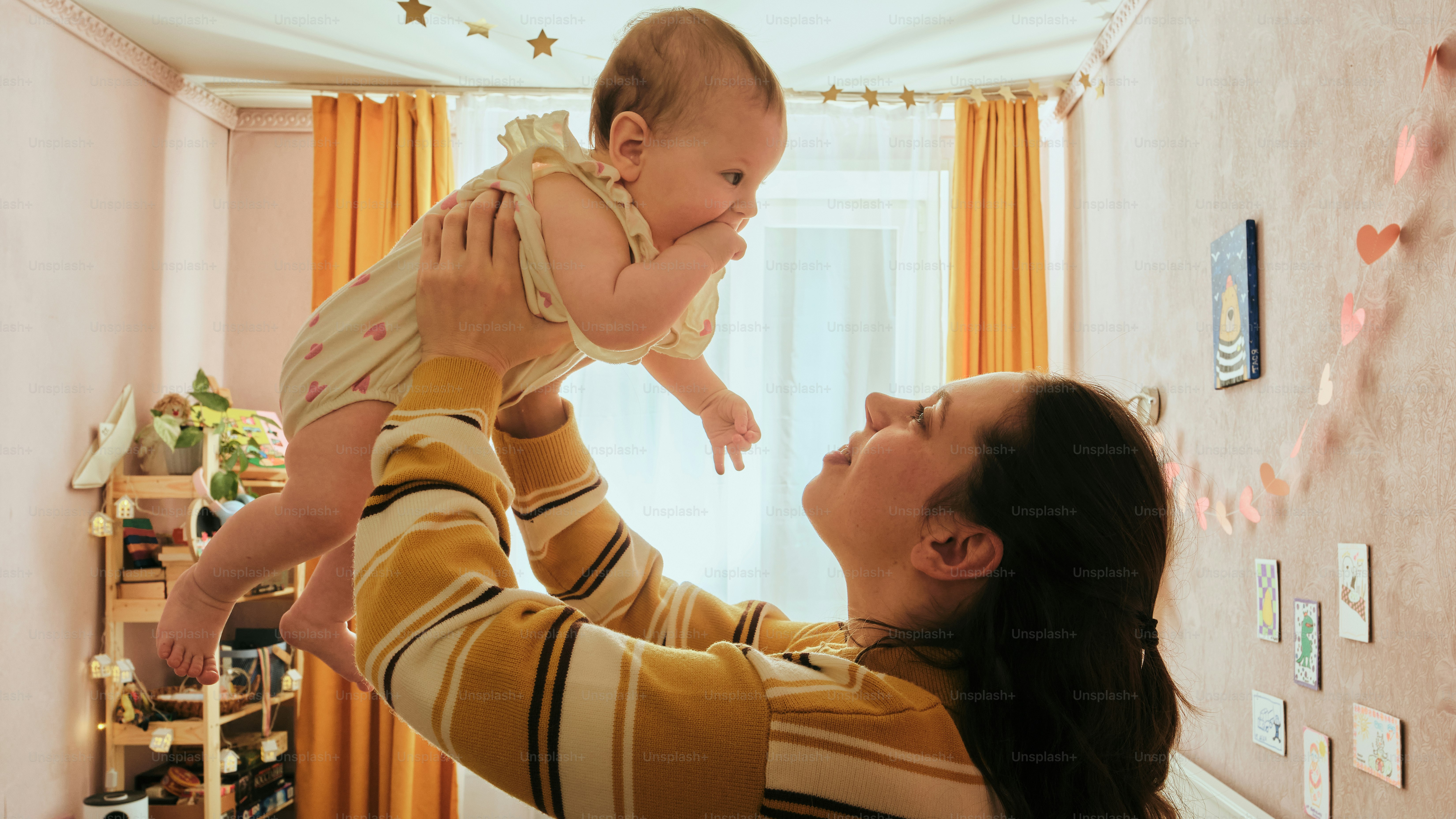 Mother holds baby up in the air