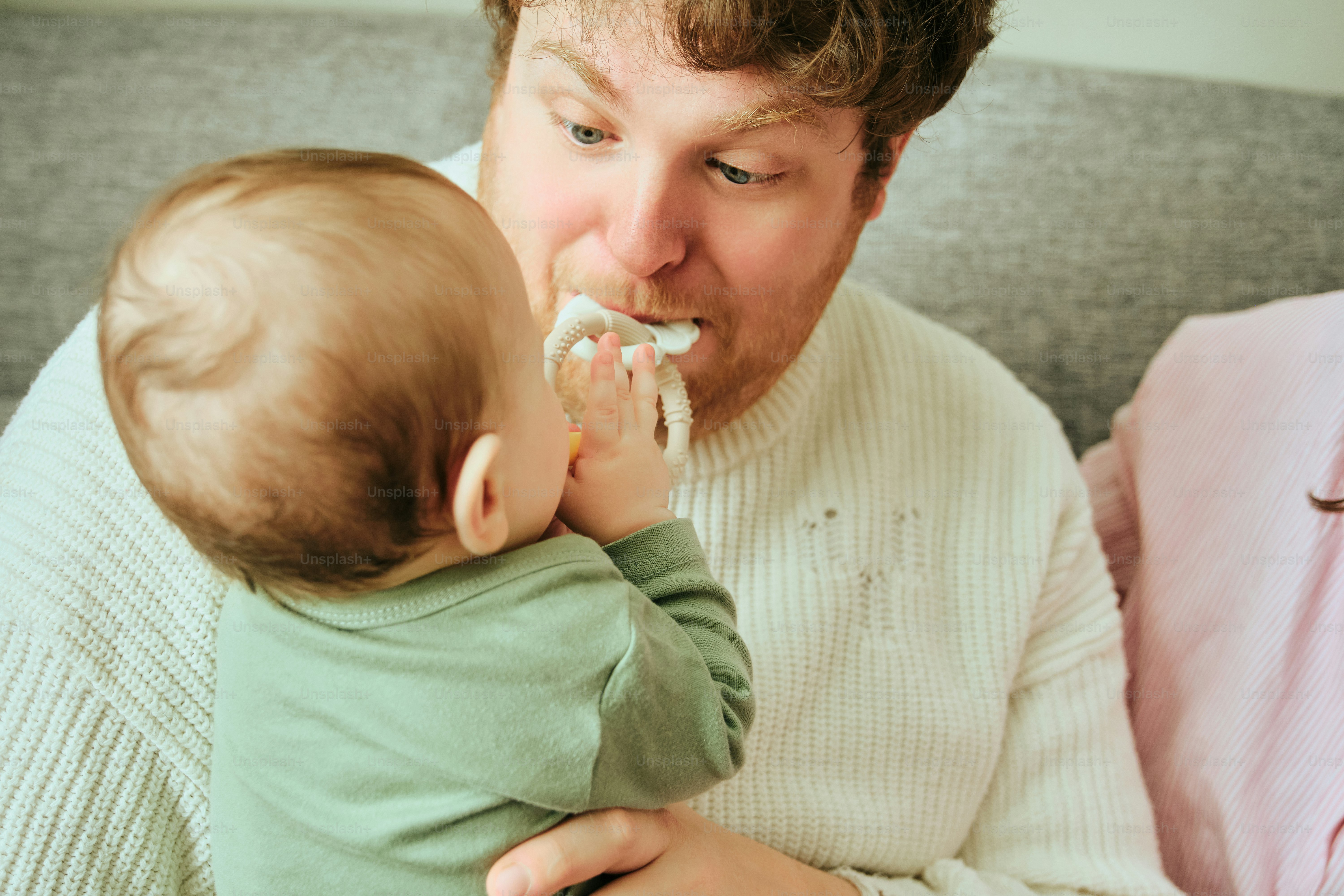 Father wipes baby's face with a tissue.