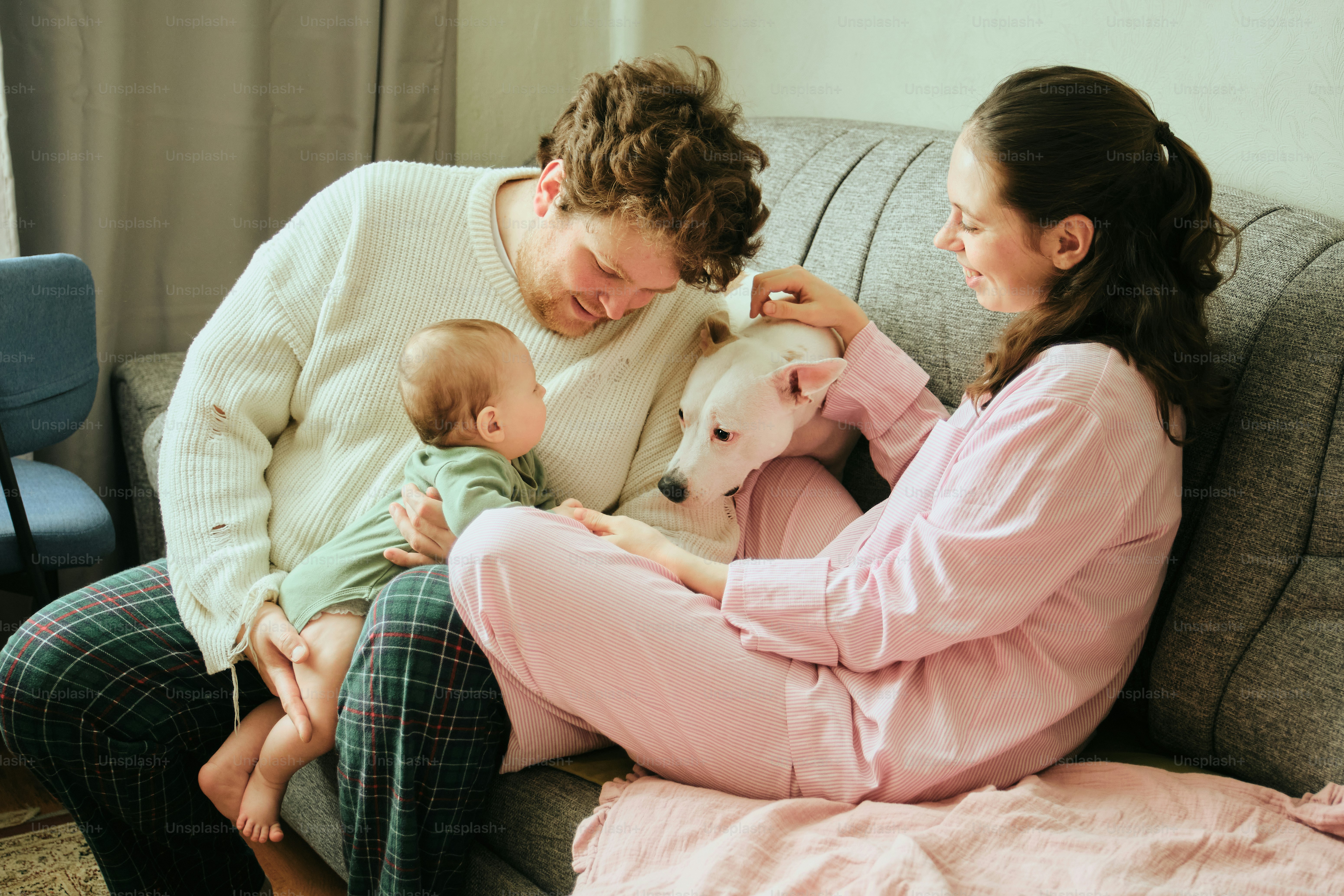 Family with baby and dog on sofa