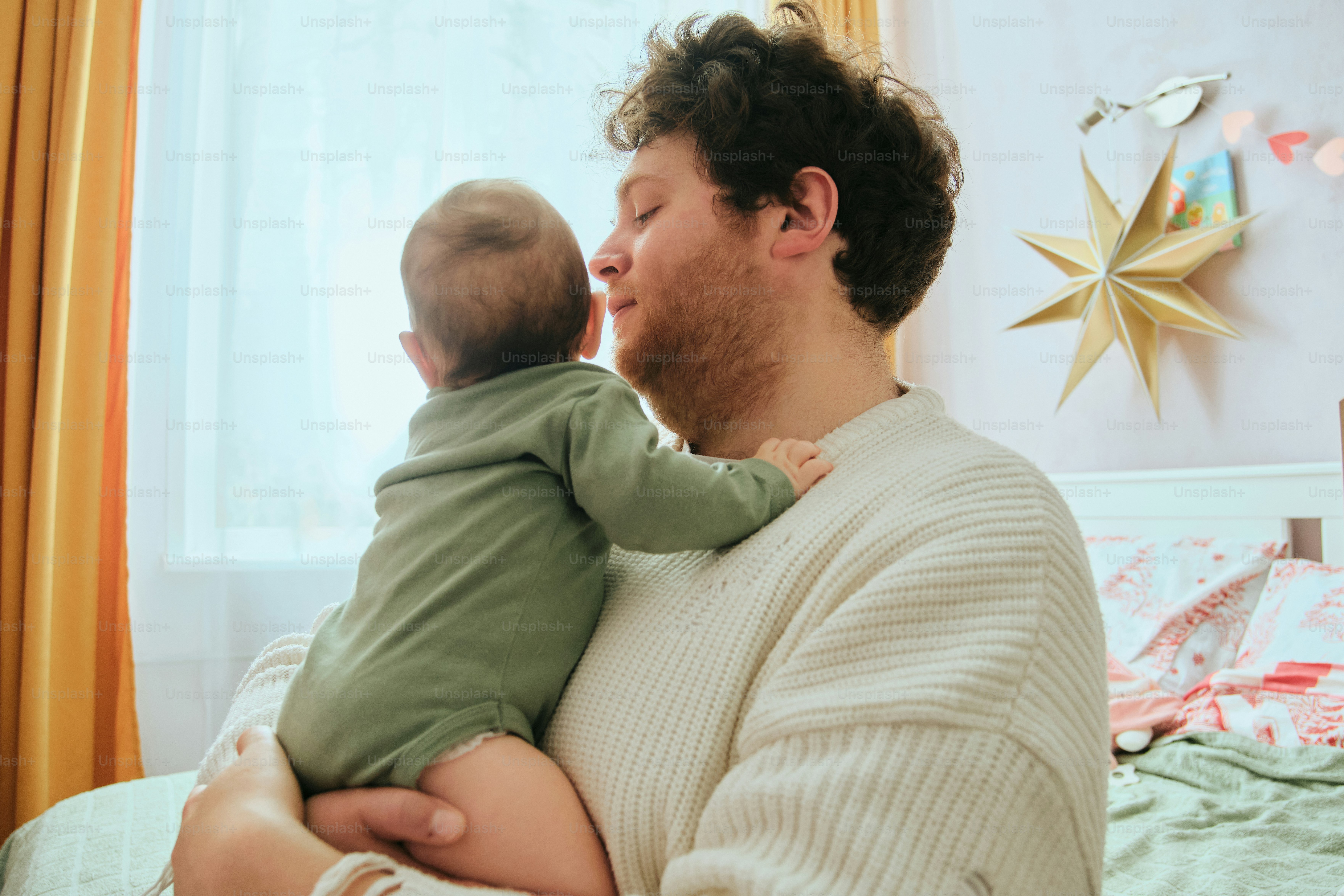 Father holding his baby near a window