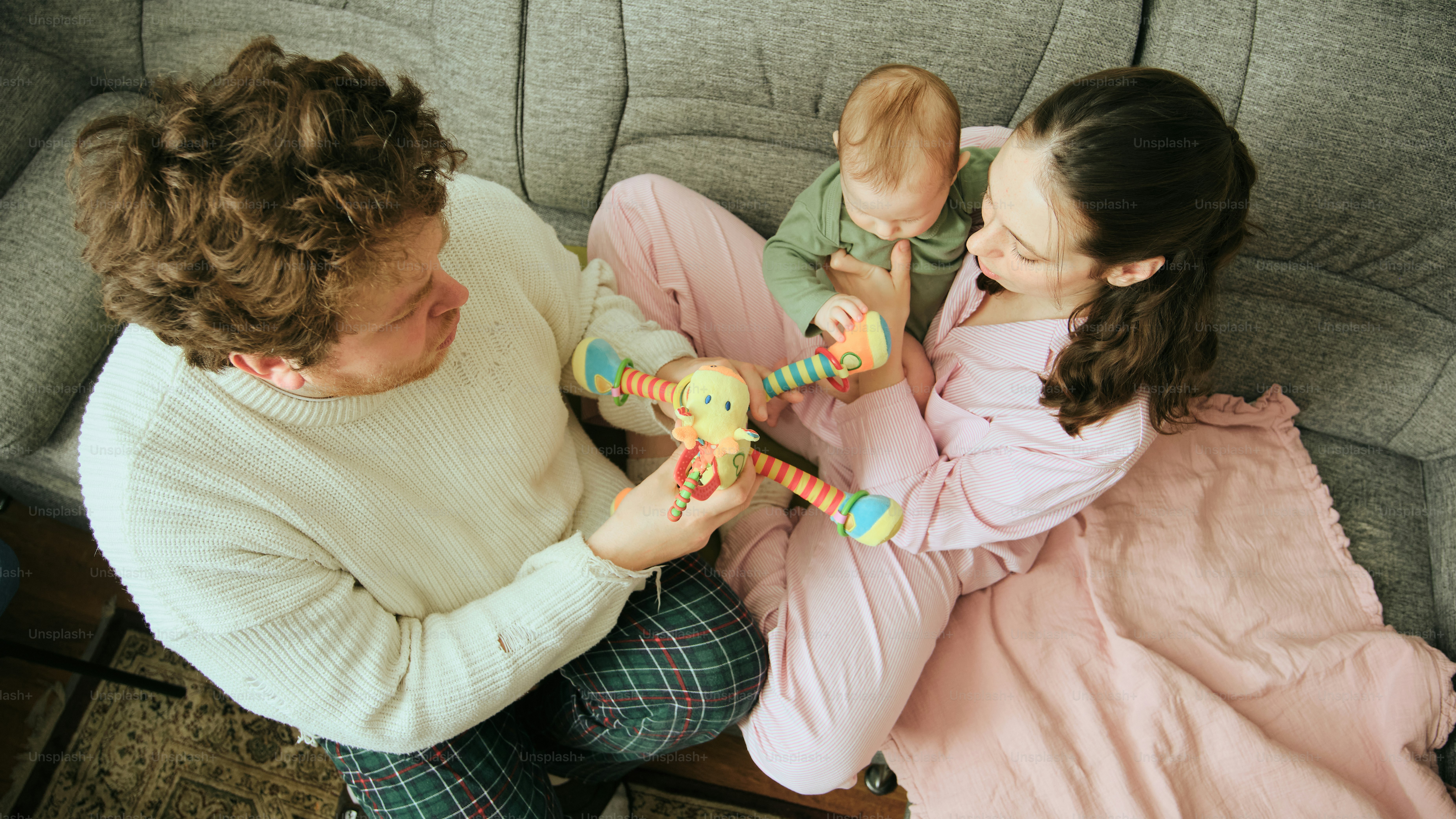 Family playing with baby on a couch