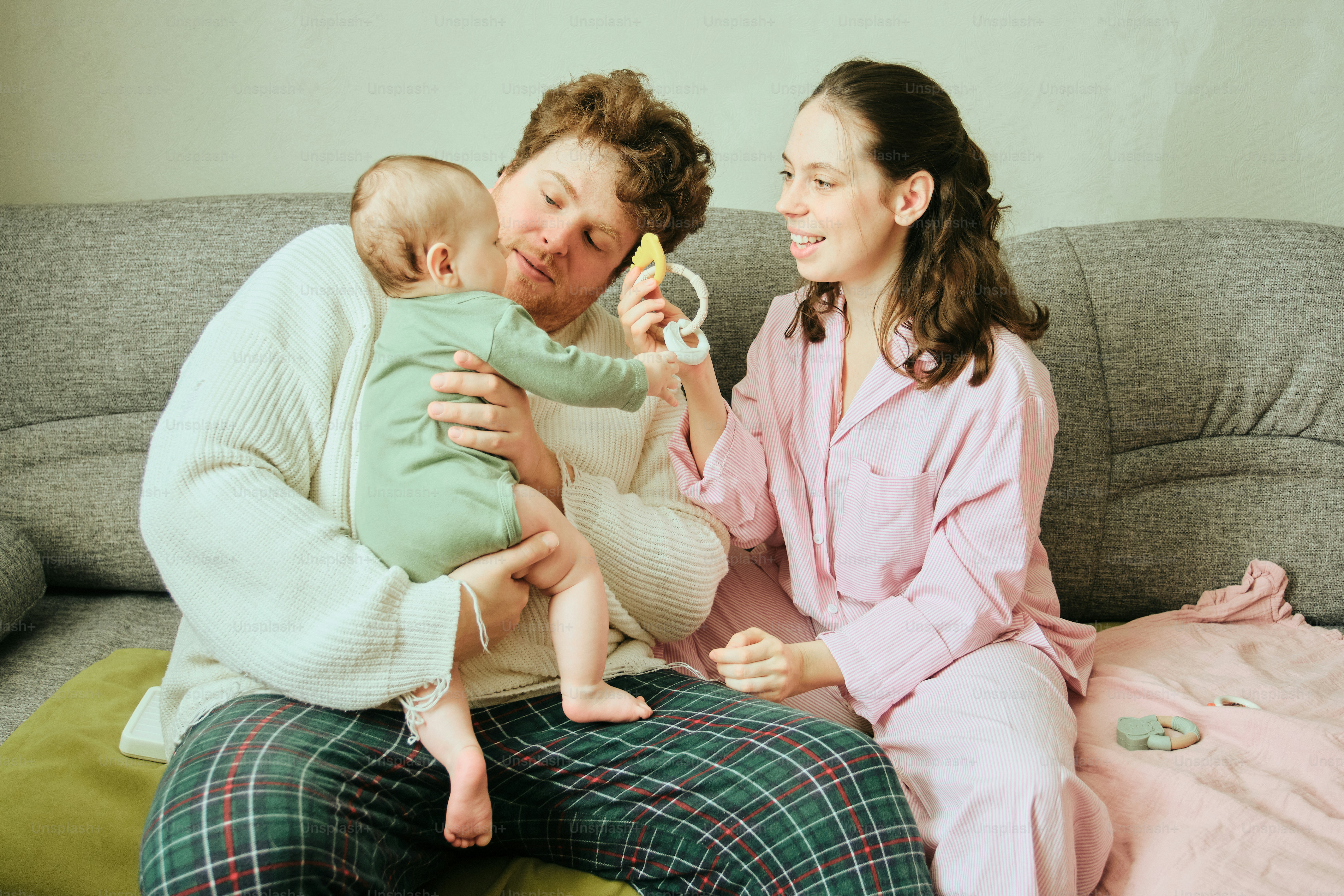 Parents playing with their baby on the couch