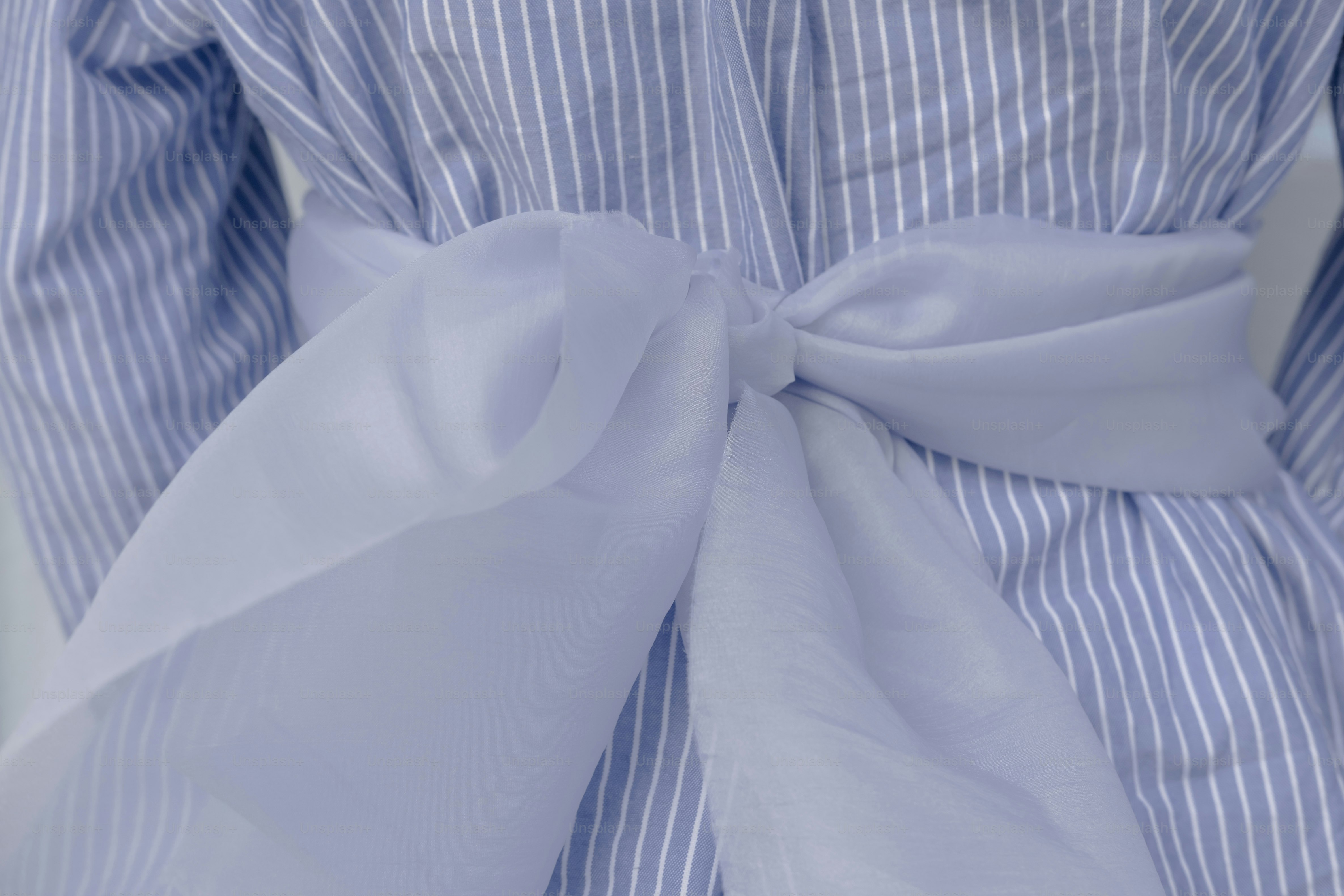 Blue striped shirt with a white bow