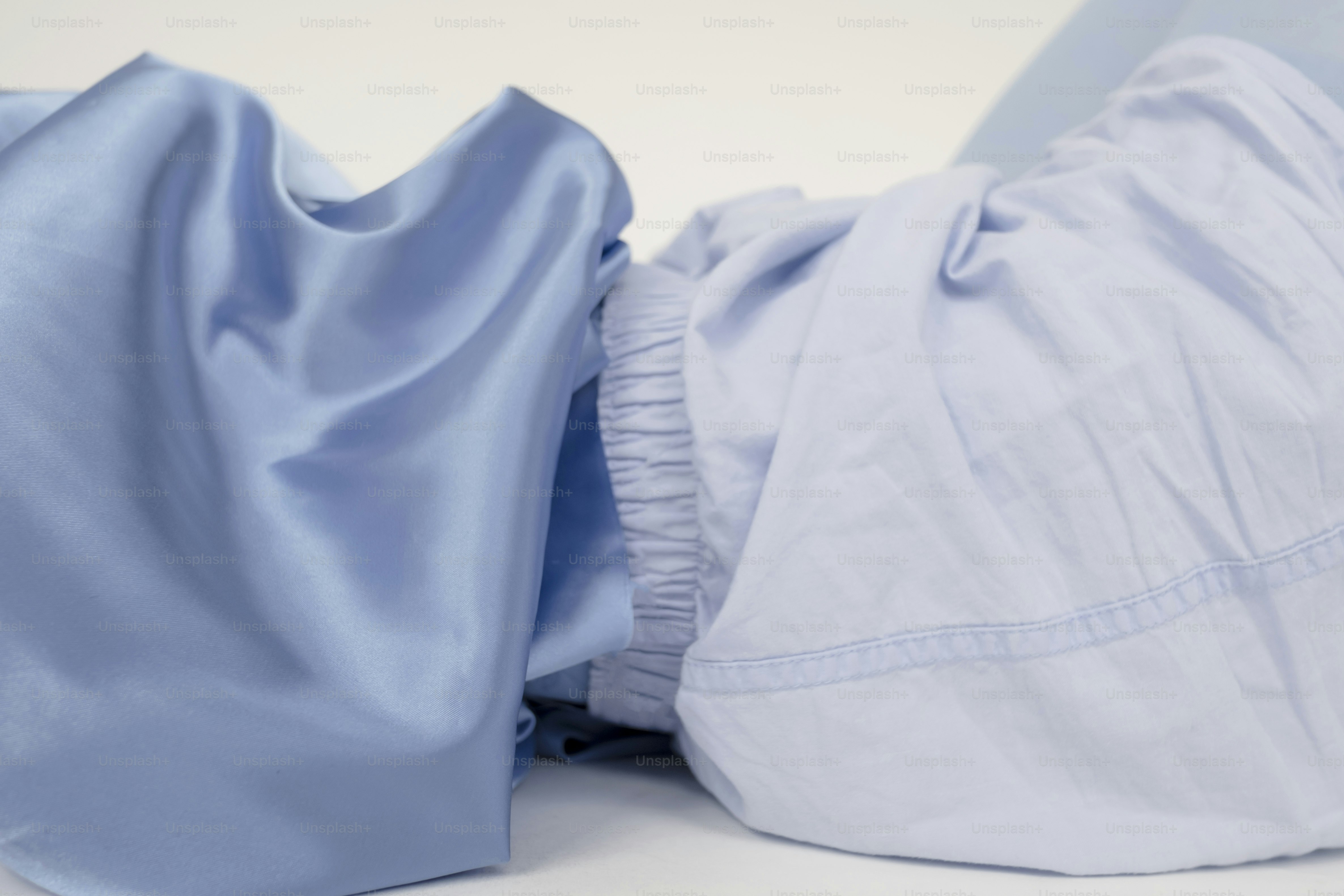 Close-up of two folded light blue fabrics.