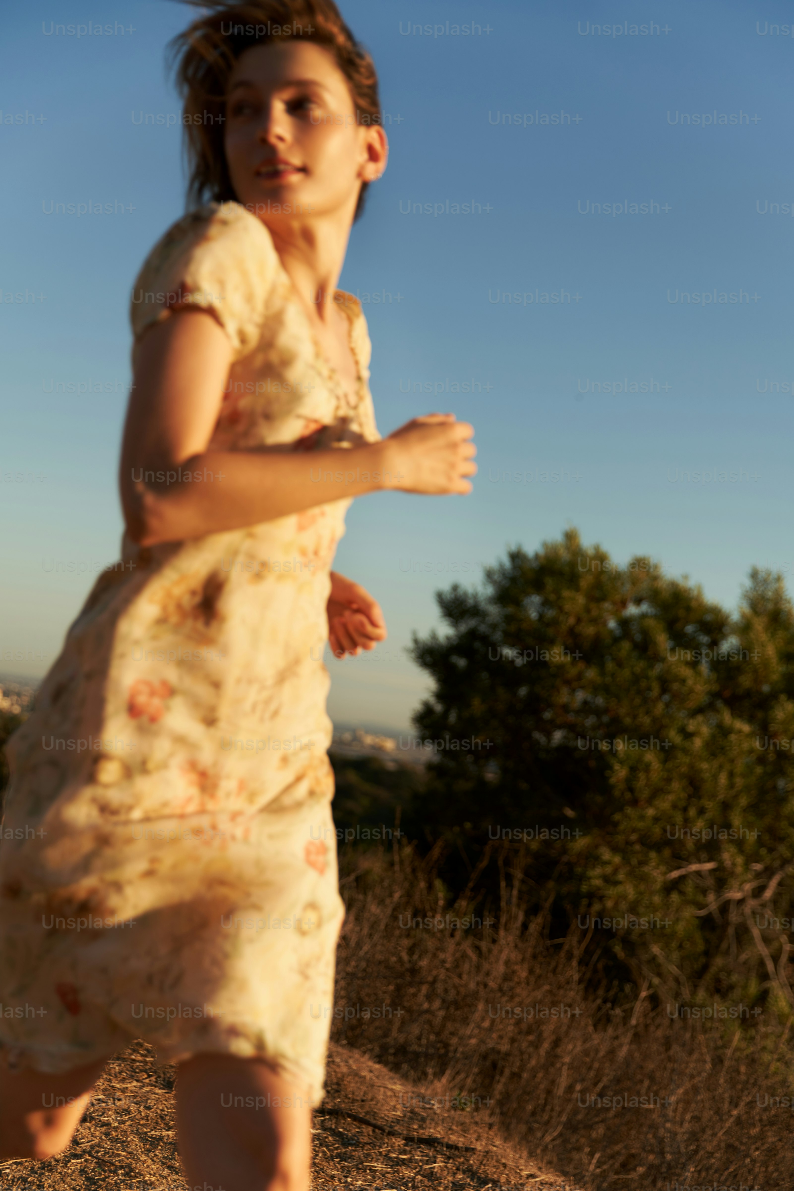 Young woman in a dress running outdoors