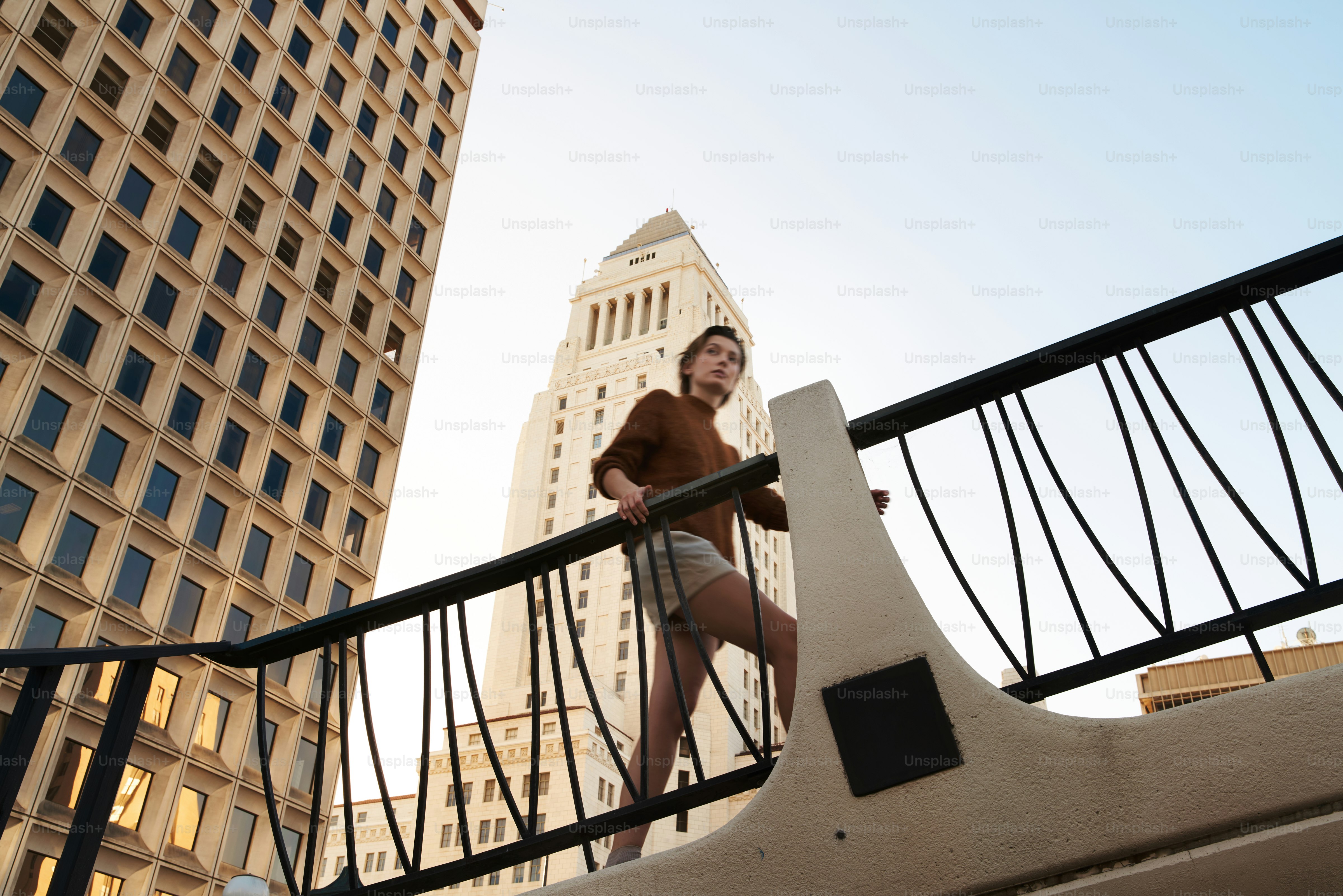 Woman climbing stairs with city buildings in background