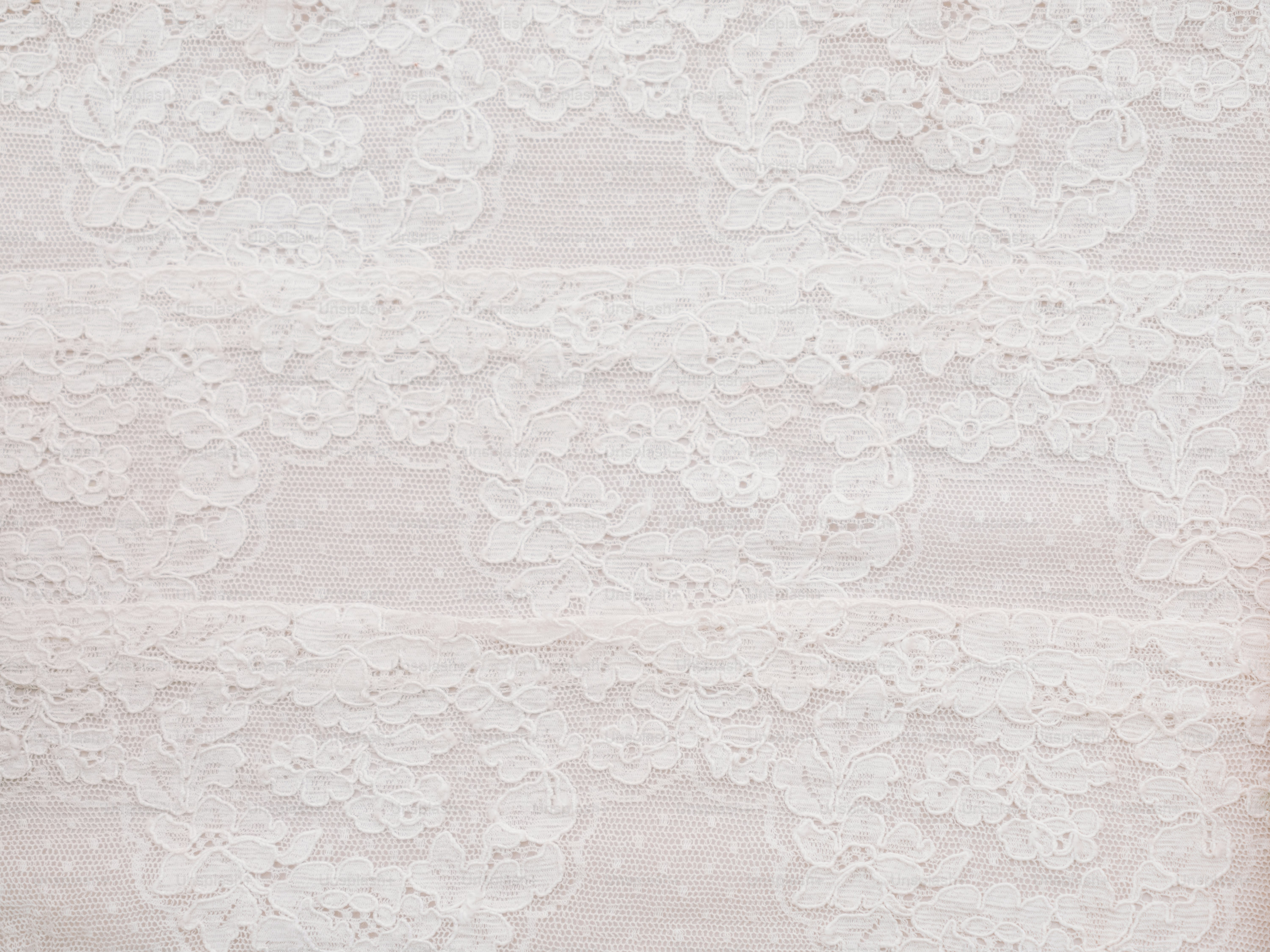 Delicate white lace fabric with floral patterns