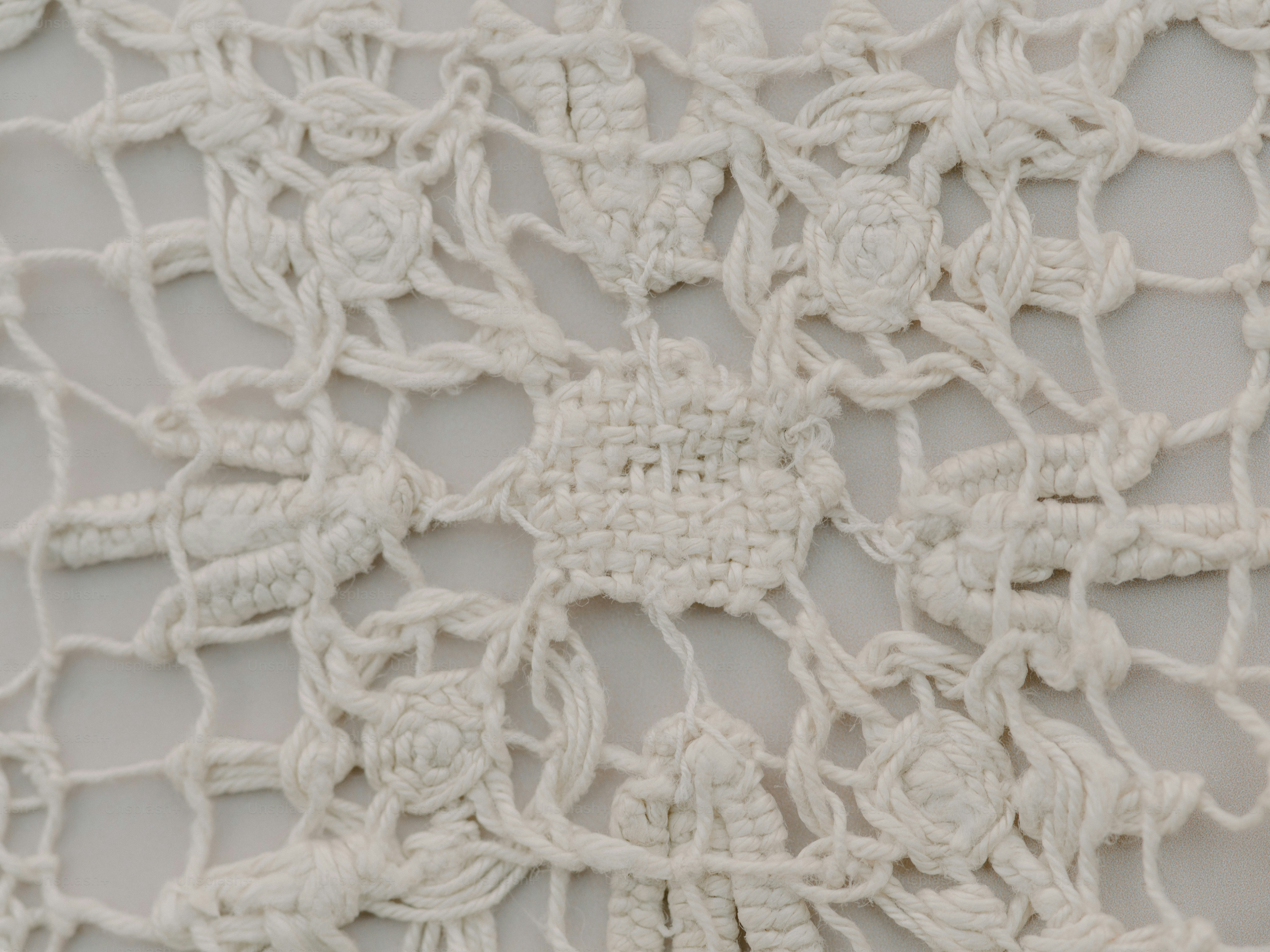 Close-up of intricate white lace fabric with floral patterns.