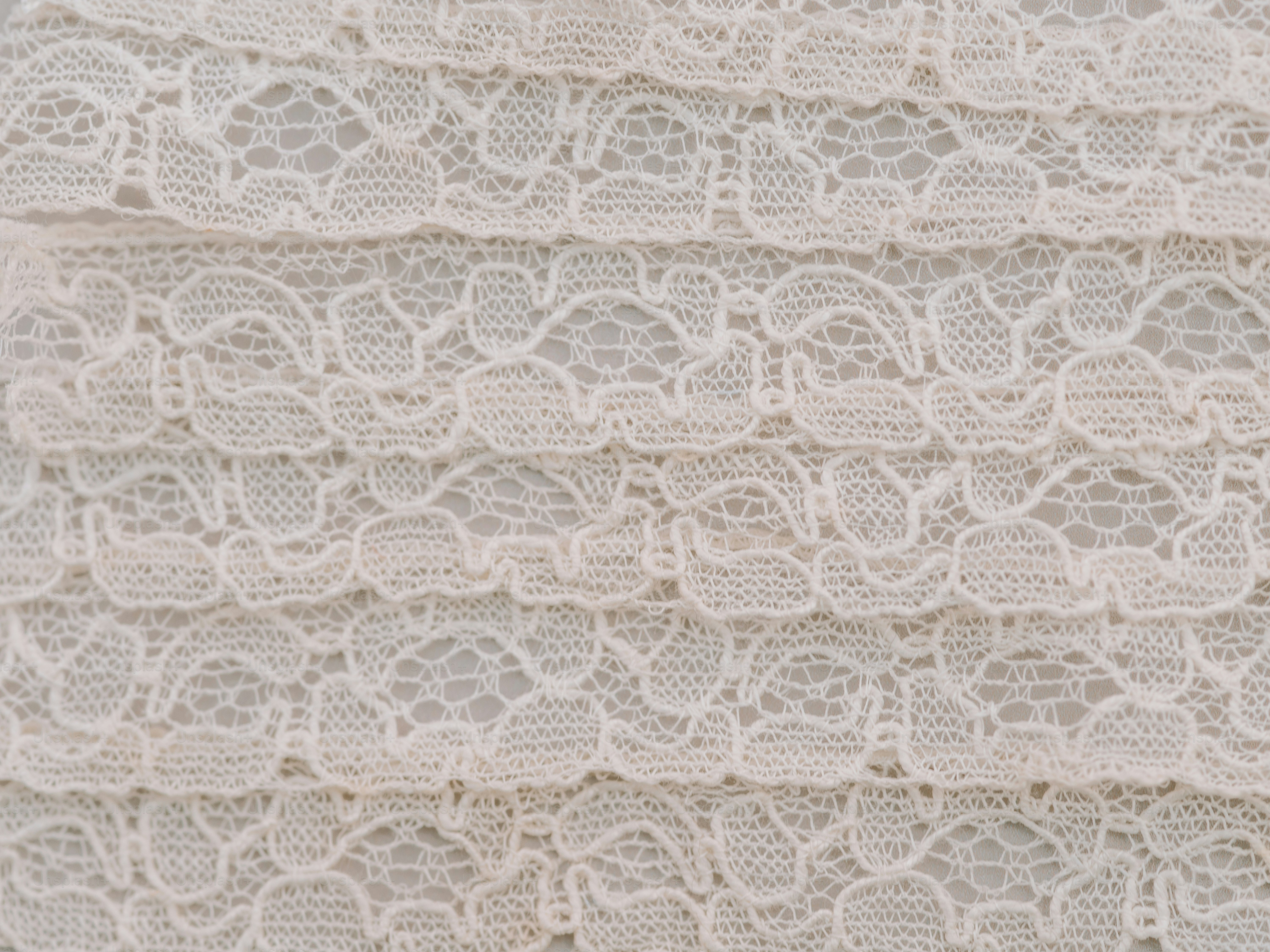 Delicate white lace fabric with horizontal ruffles.