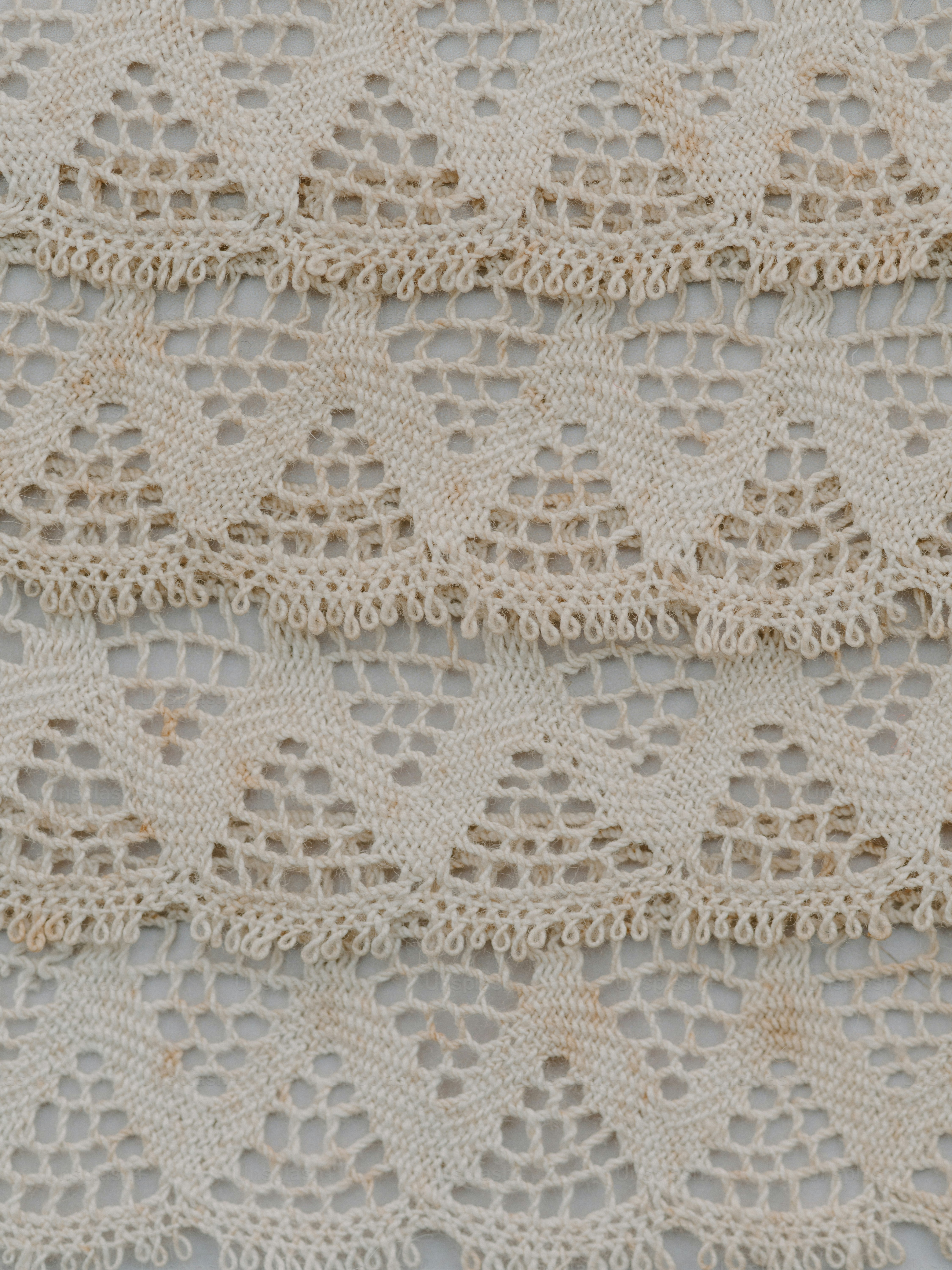 Close-up of vintage cream lace trim with intricate patterns