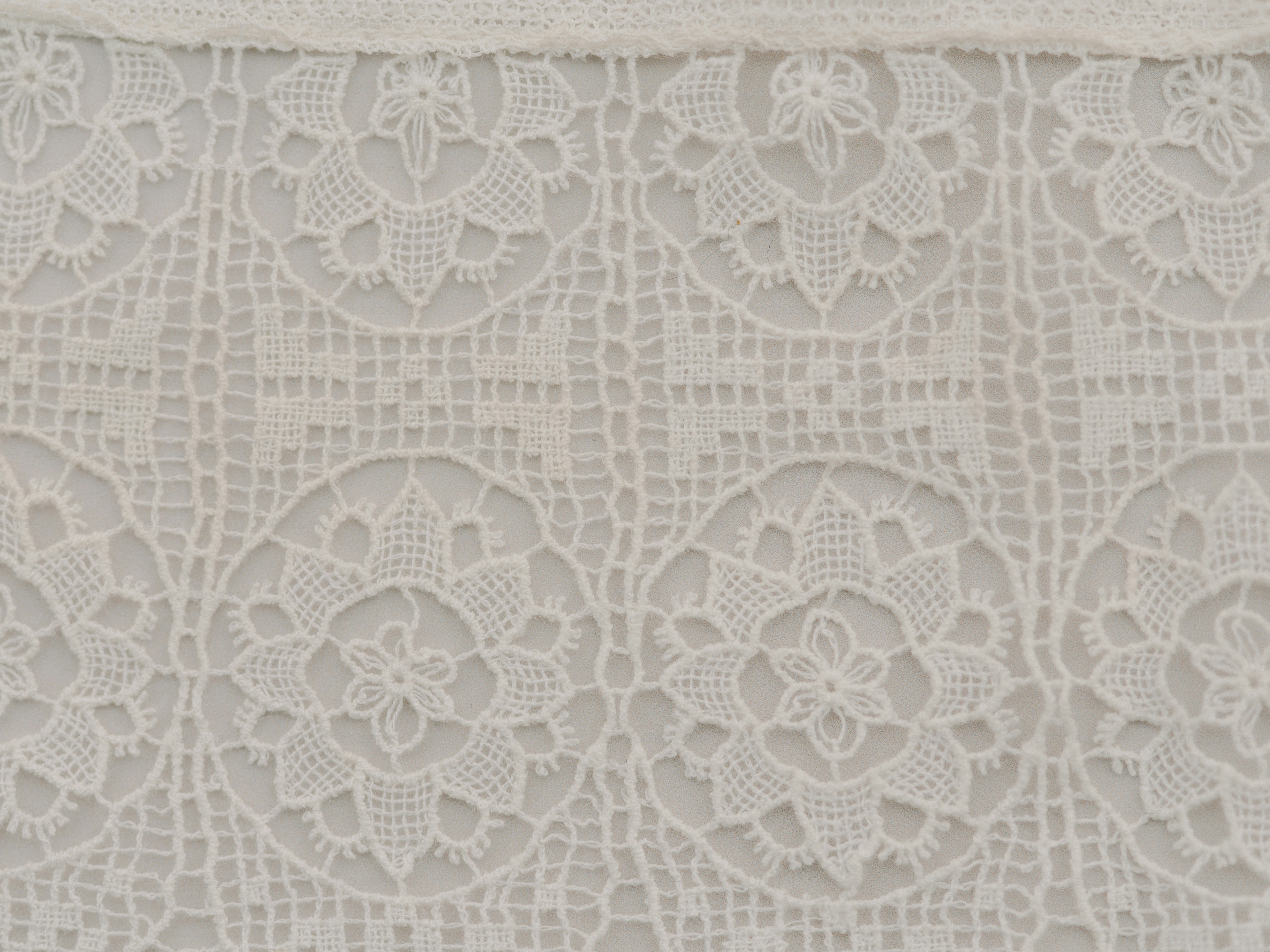 Close-up of white lace fabric with floral patterns