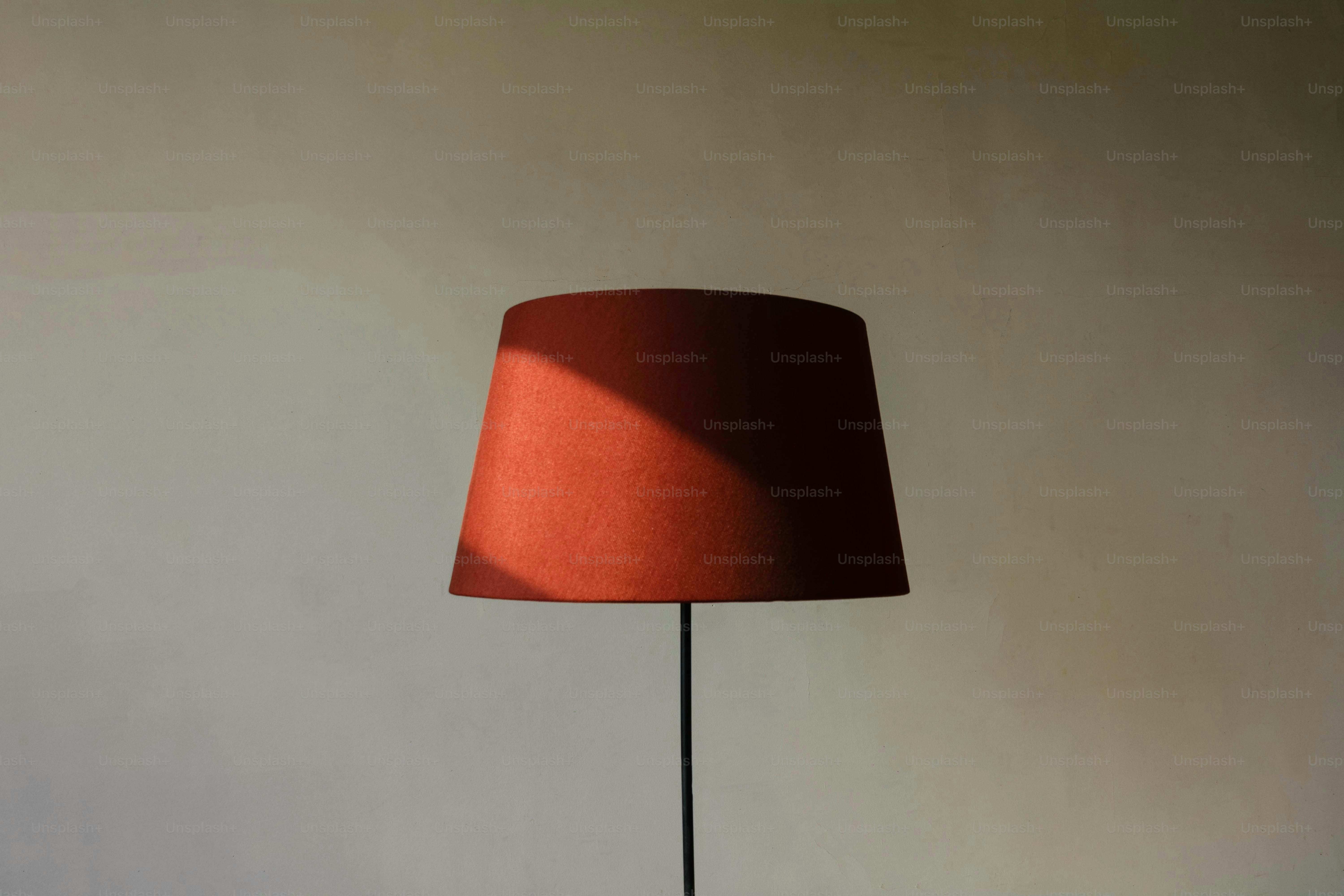 A red lampshade with dramatic shadows