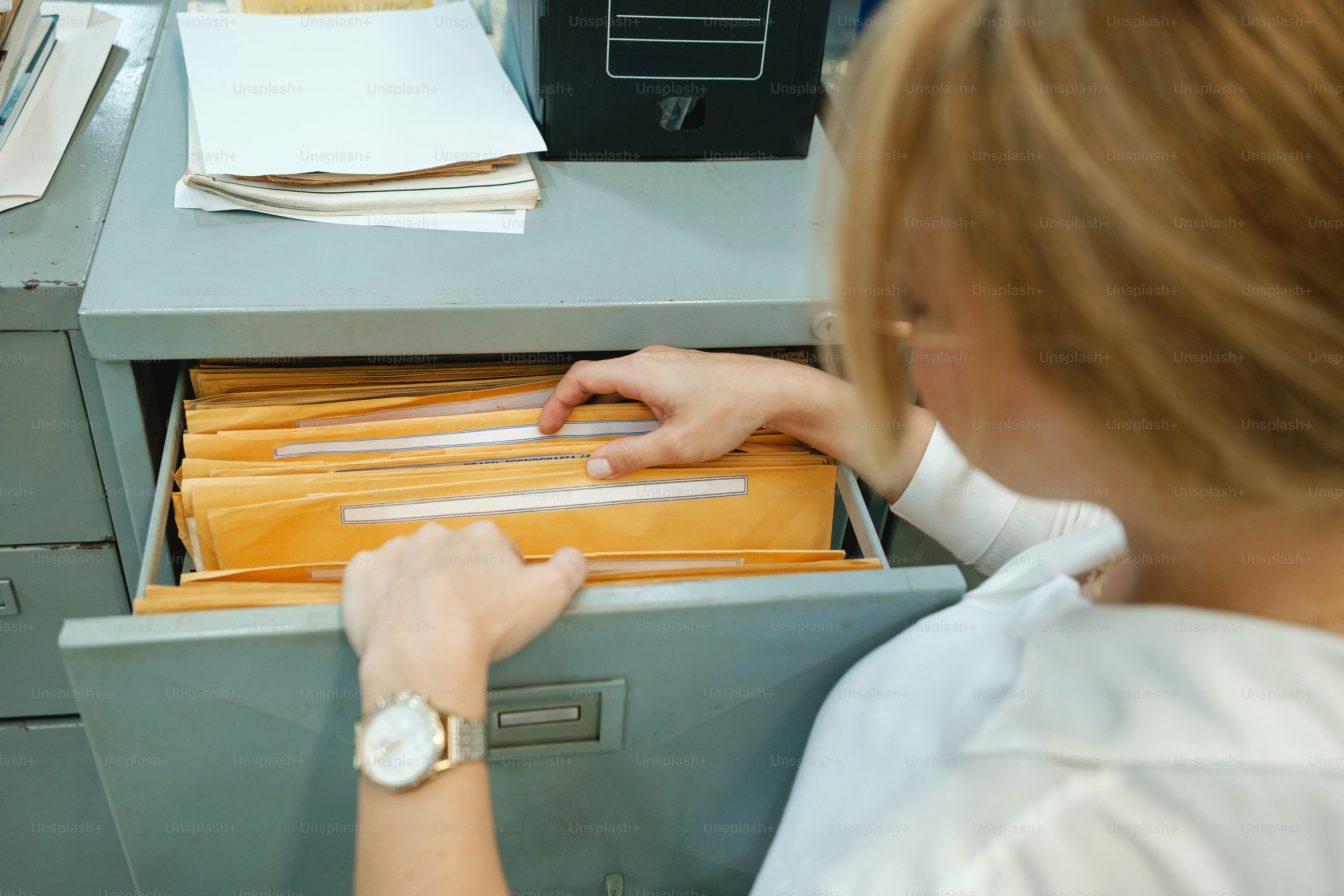Woman searching through files in a cabinet