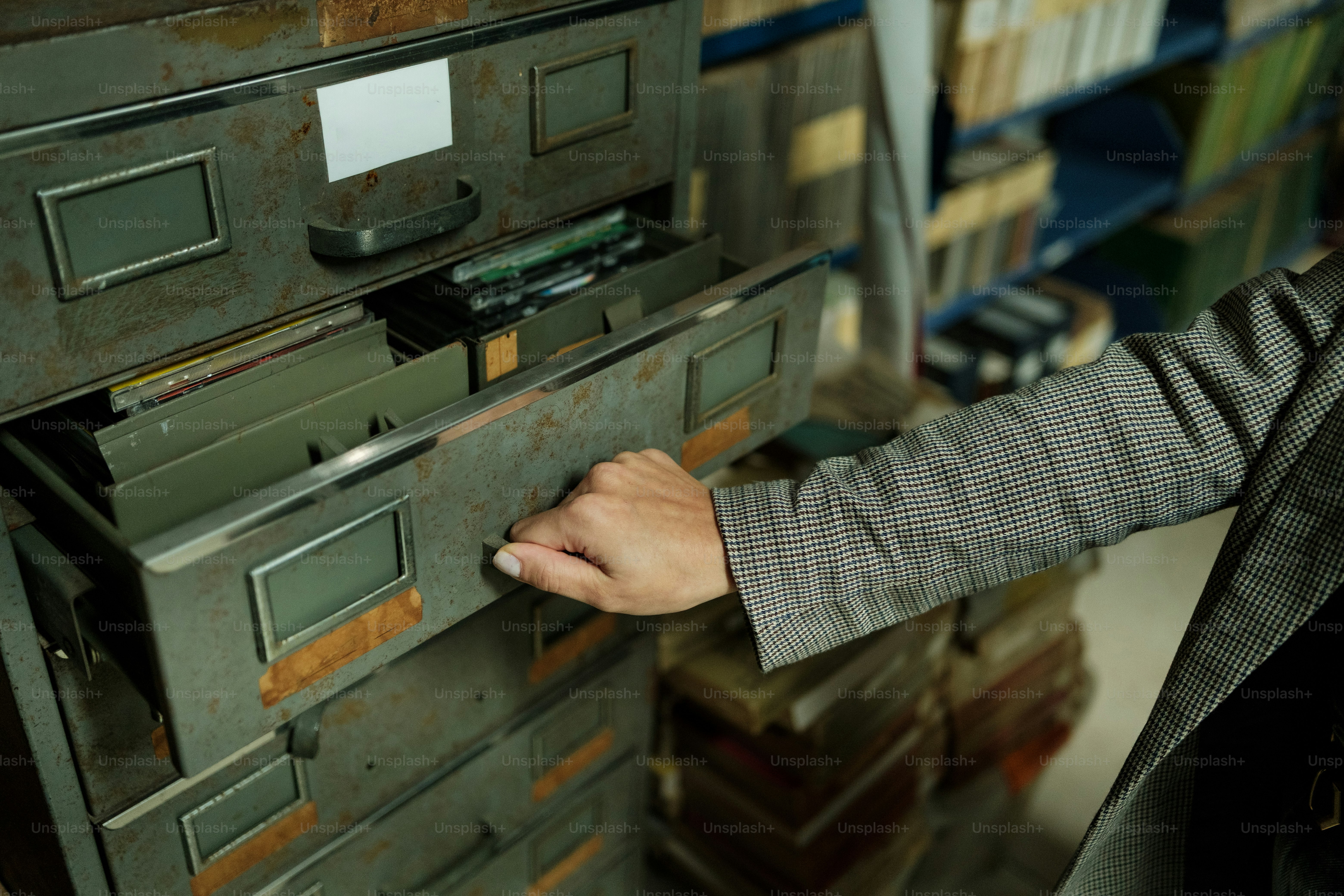Hand opening a vintage filing cabinet drawer